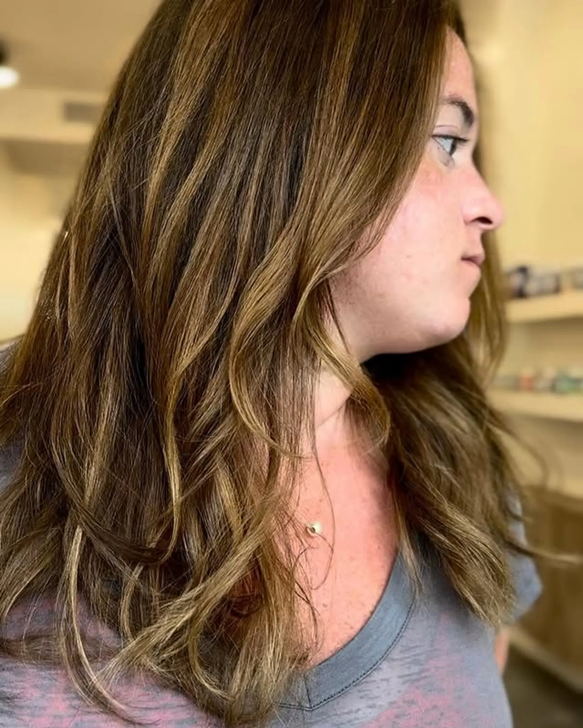 A layered medium length cut with bronde balayage and loose beachy waves. 1