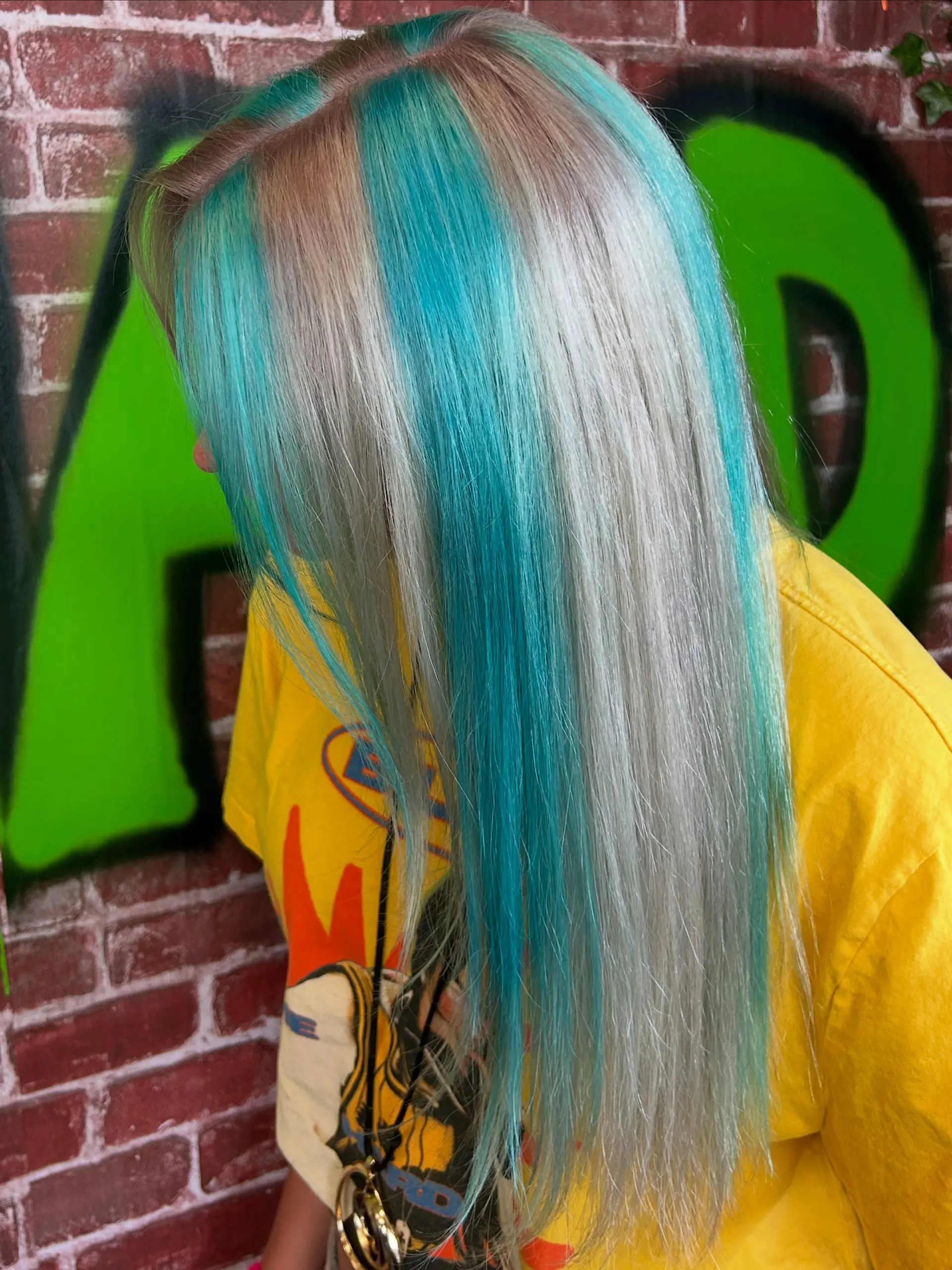 Long straight platinum hair styled with bold, vibrant teal chunky streaks and color blocking. 1