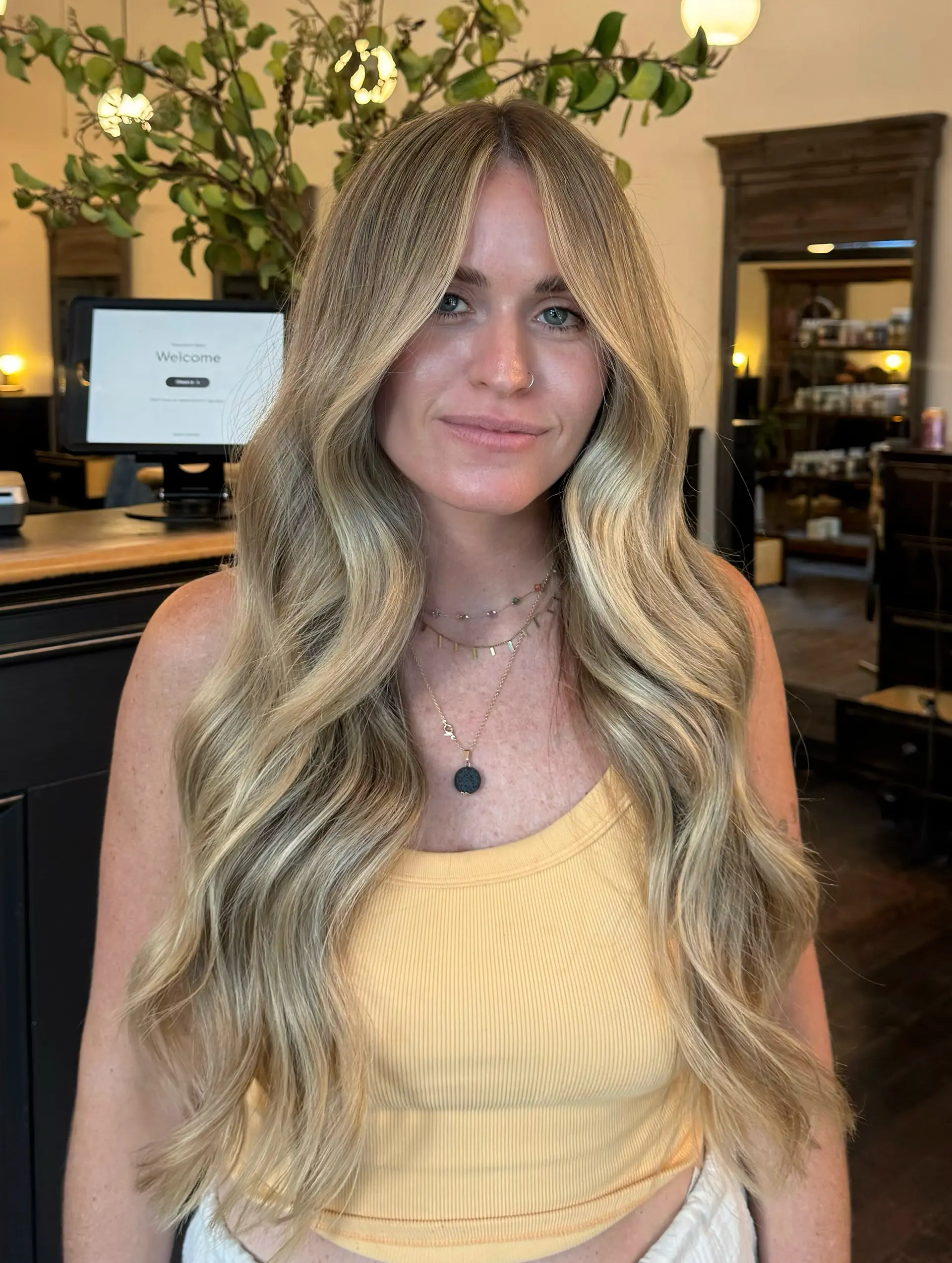 Long center-parted hair featuring dimensional blonde highlights styled into soft, beachy waves. 1