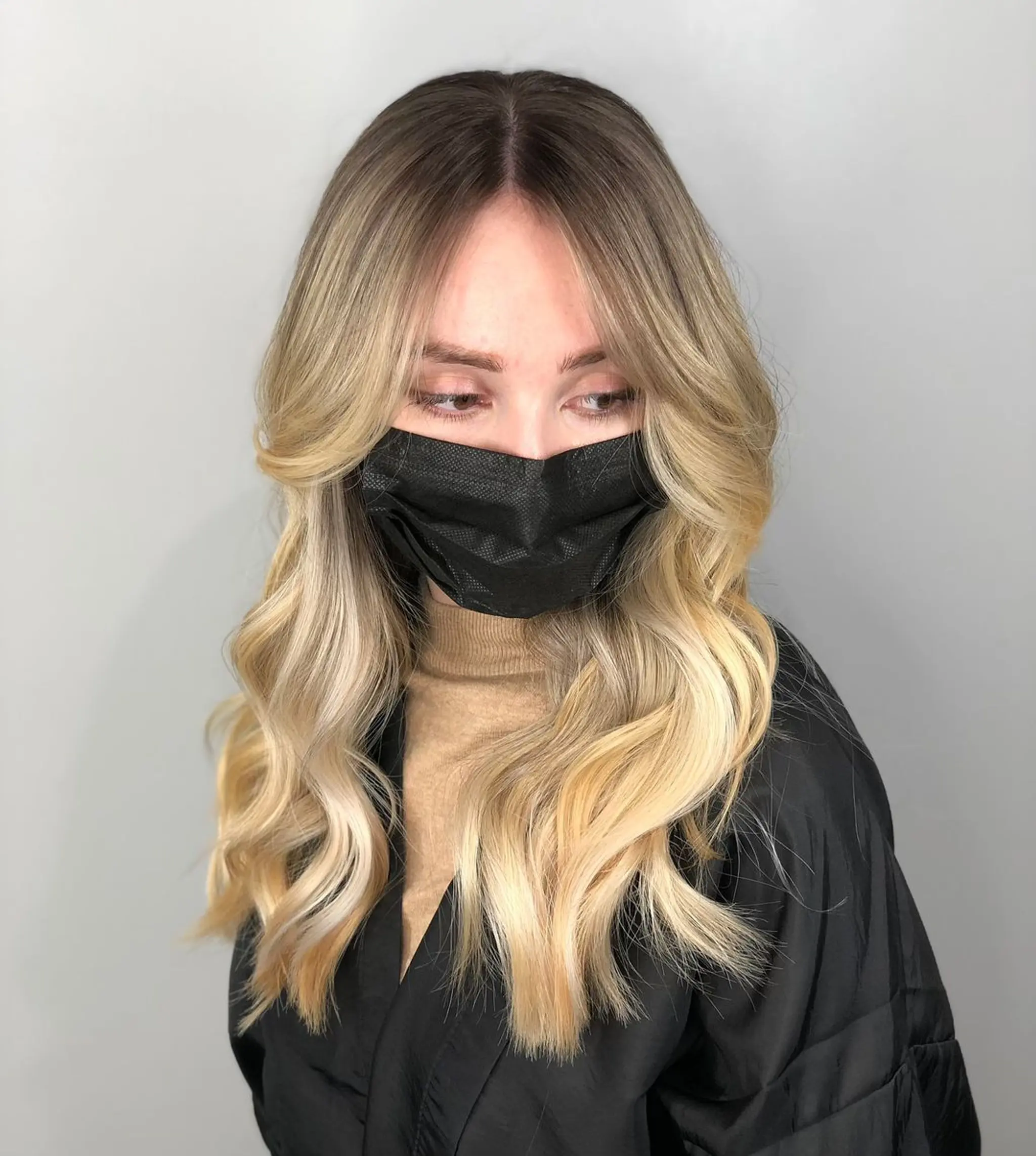 Long, wavy hair with dark blonde roots transitioning to light, golden blonde ends. Features a center part and soft, loose waves with face-framing layers.
Stylist - @xcellent_jason