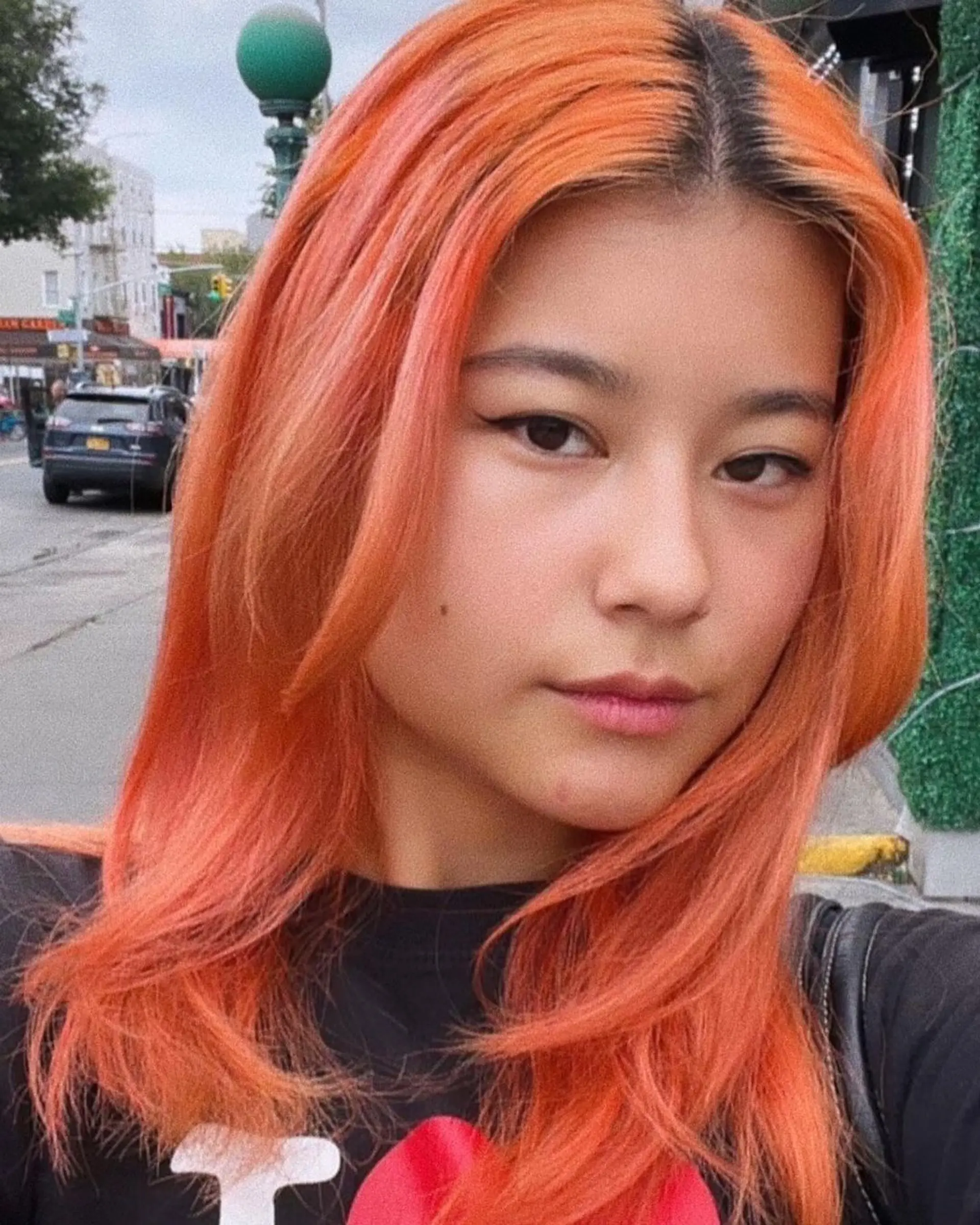 A vibrant, medium-length straight hairstyle with orange and peach tones. Features subtle layers and face-framing pieces. 1