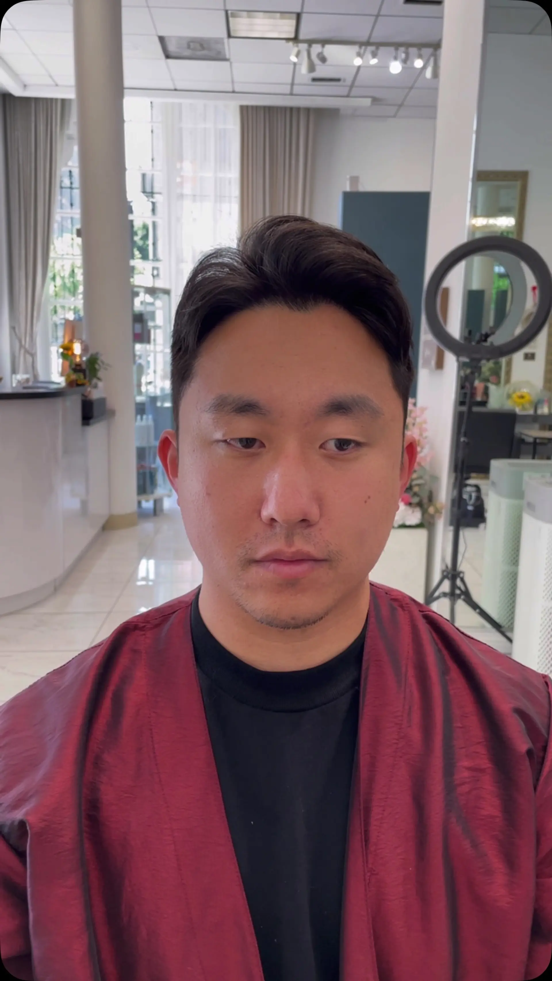 A short men's hairstyle featuring root volume and a soft, parted fringe swept back from the forehead. 1
