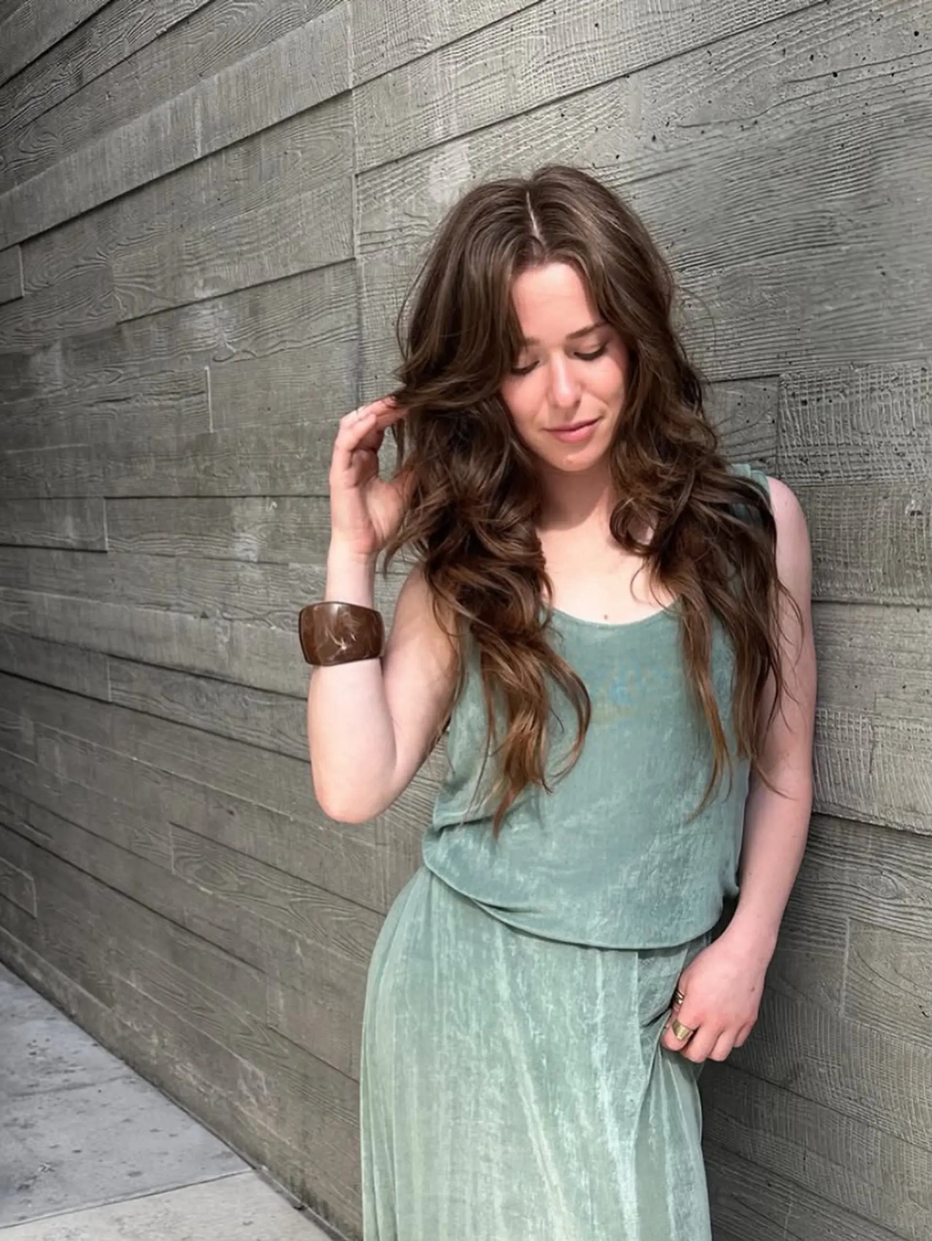 Long brunette haircut featuring soft face-framing layers and loose, textured waves. 1
