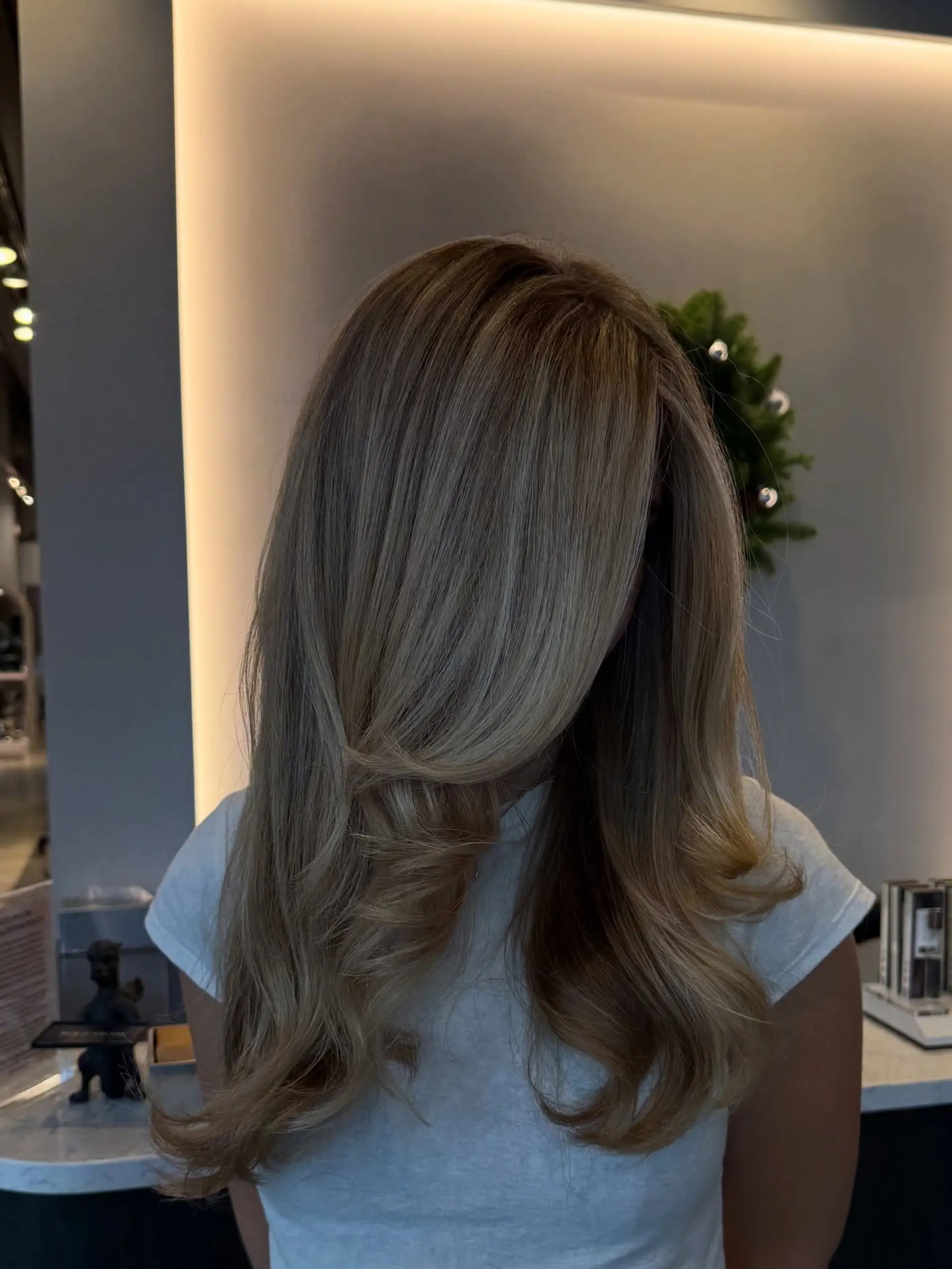 Long butter blonde hair cut with face-framing layers and styled in a bouncy, voluminous blowout. 1