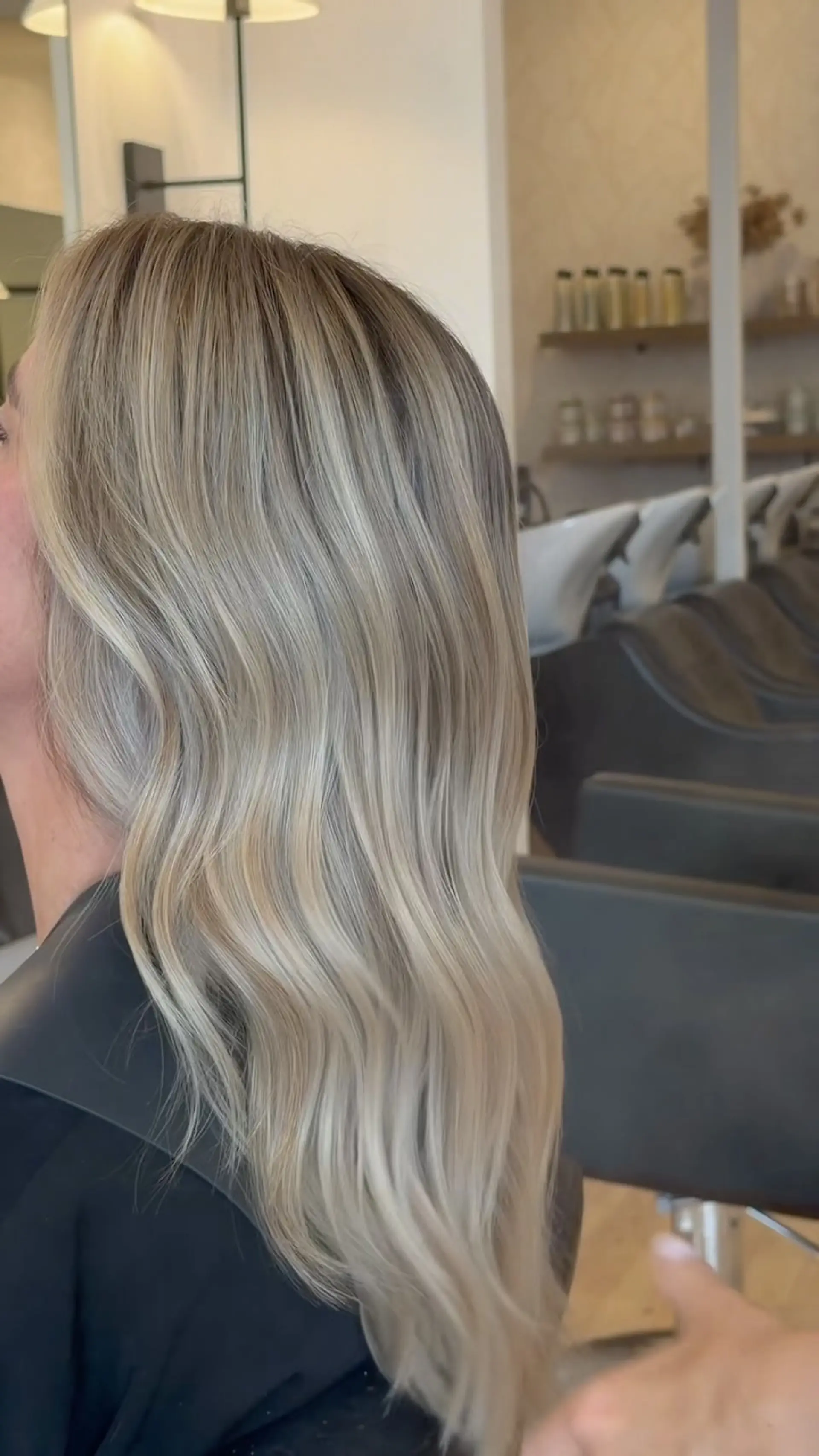 Long dimensional blonde hair seamlessly blended and styled into soft, elegant waves. 1
