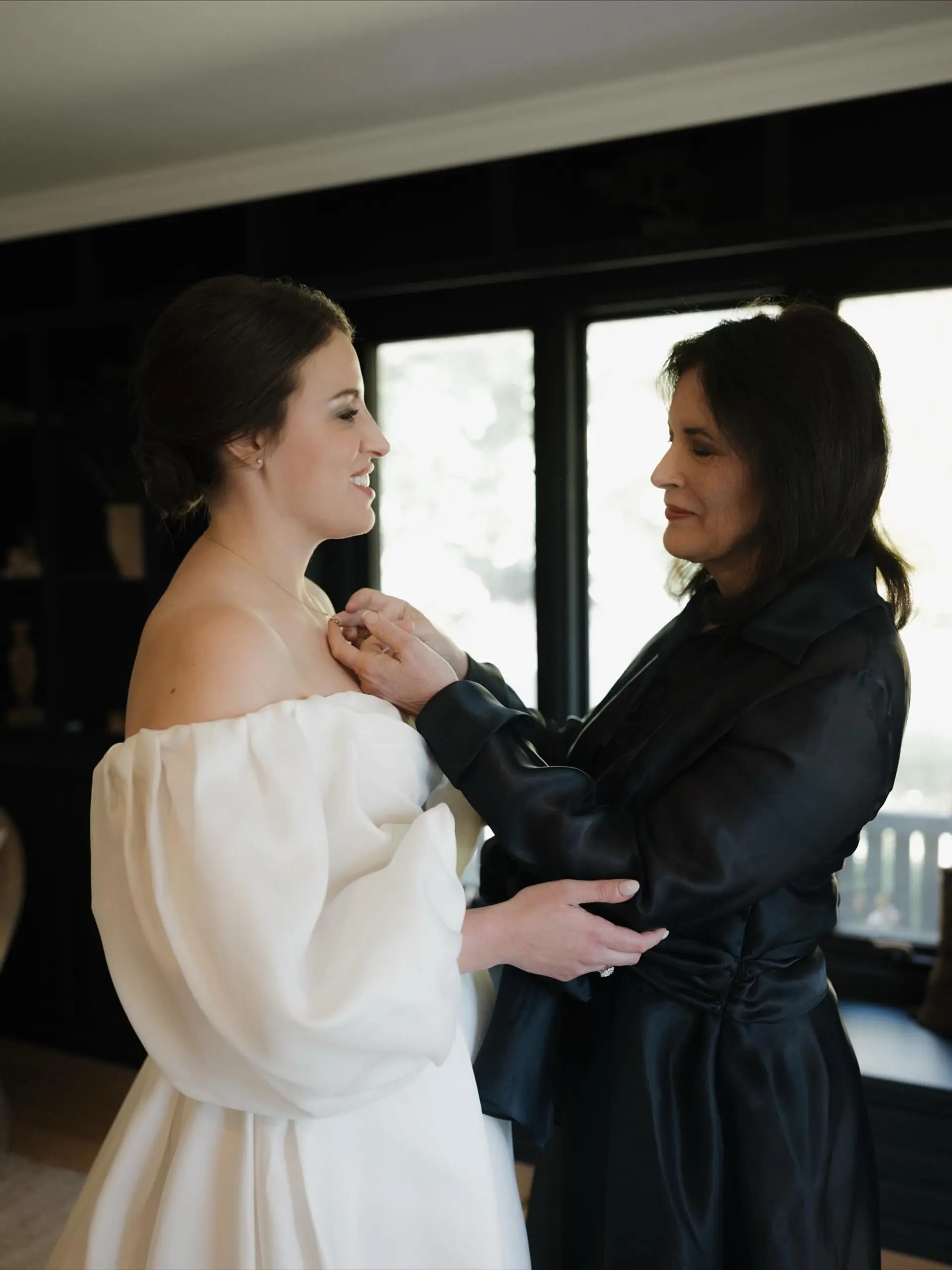 An elegant bridal updo featuring sleek hair swept into a clean low bun at the nape of the neck. 1