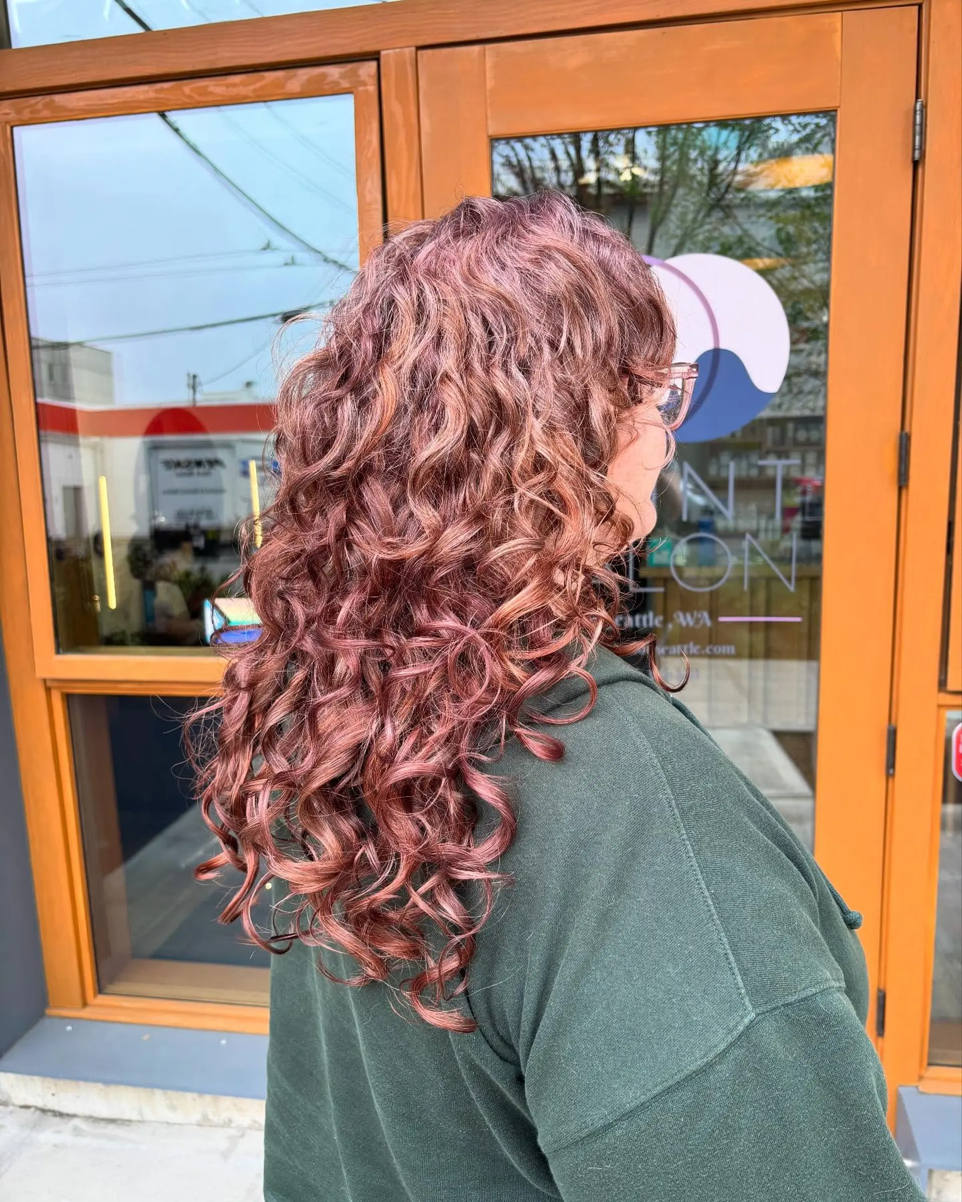 Long layered cut shaped specifically for natural curls to enhance bounce, volume, and definition, featuring a glossy dusty rose tone. 1