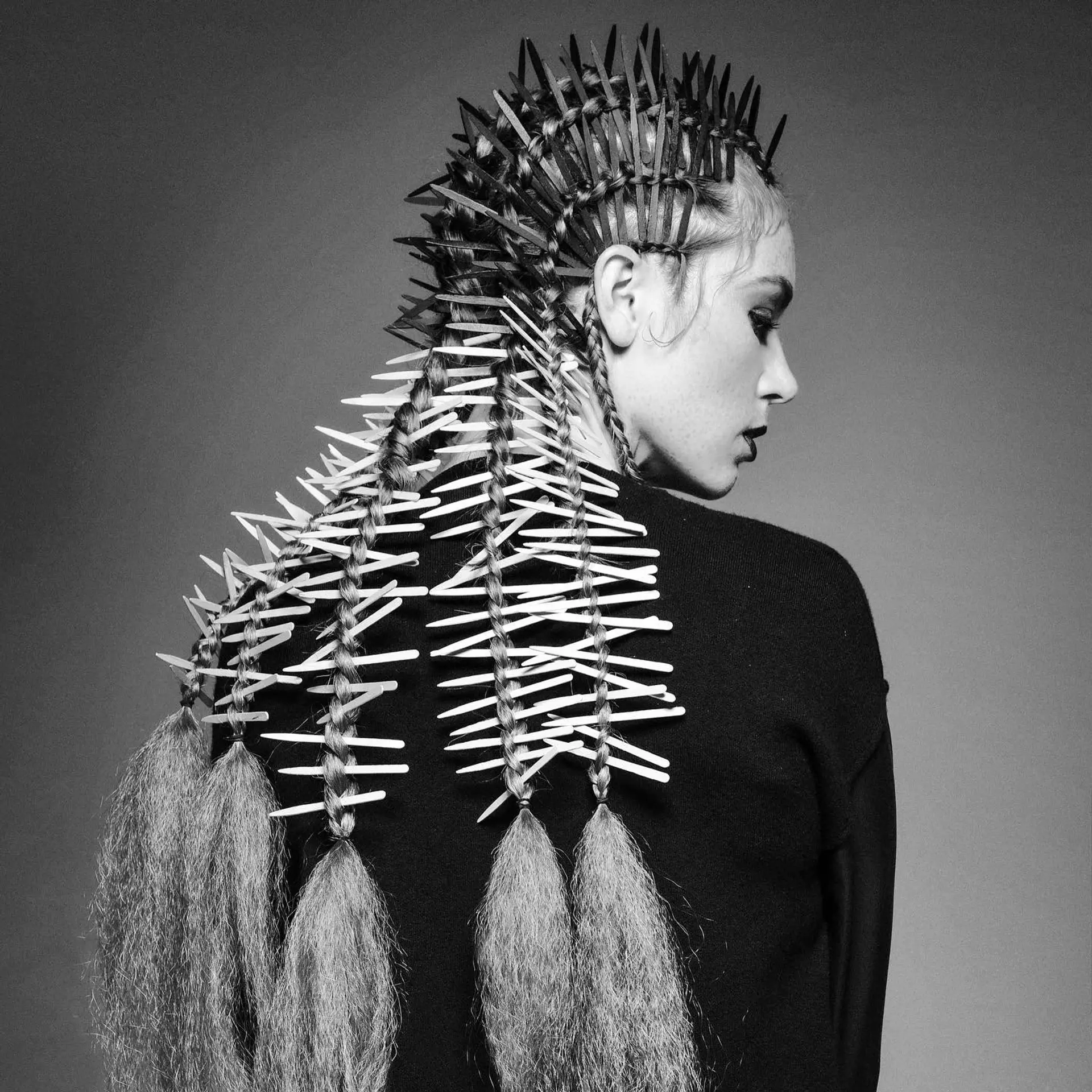 Sculptural braided mohawk featuring quill-like spikes interwoven into multiple braids that finish in voluminous textured tails. 1