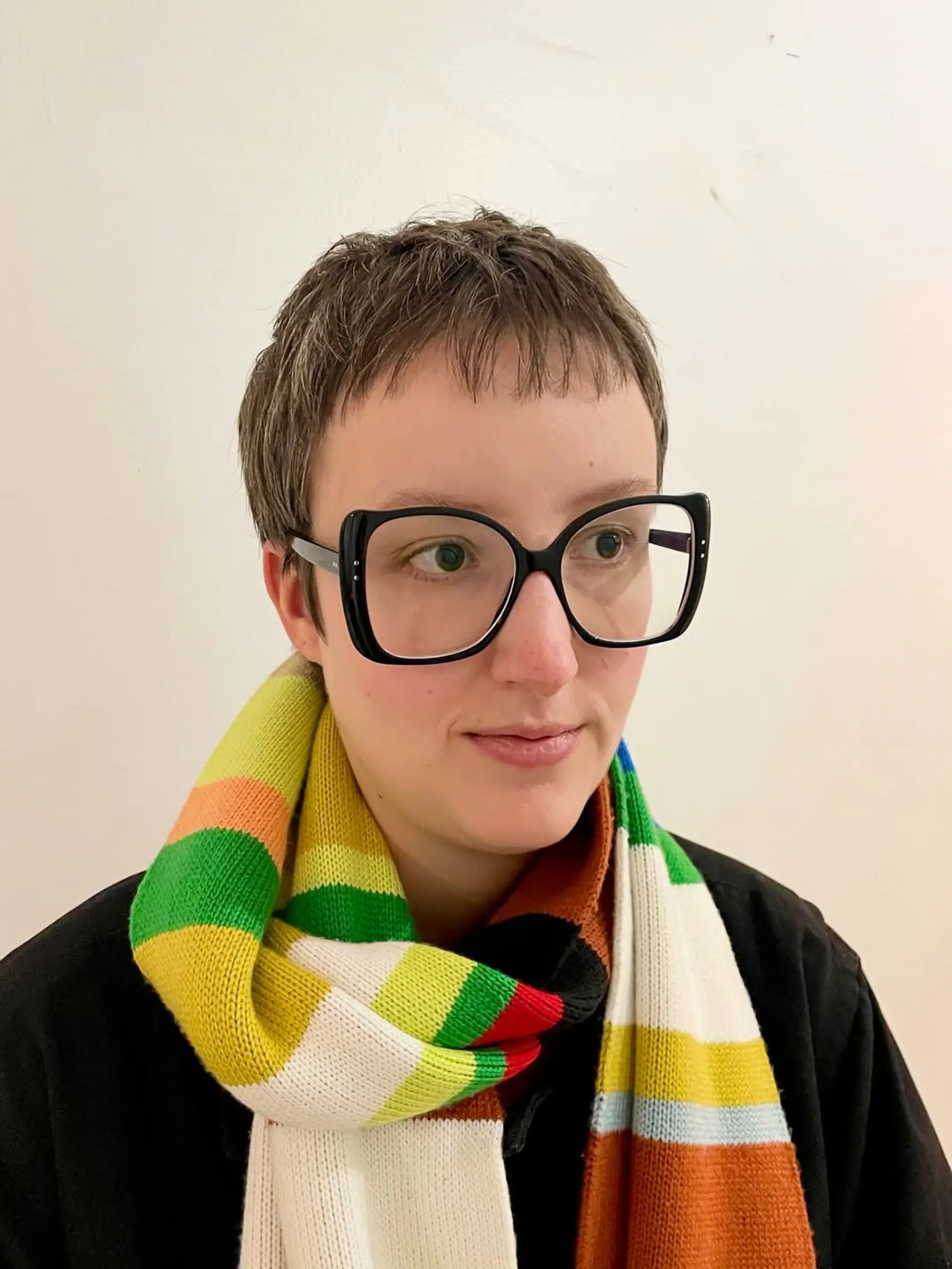 This haircut is a modern, textured pixie with choppy layers throughout, giving it a natural, slightly undone look. It features short, blunt micro bangs that sit high on the forehead, framing the face with an edgy appeal. 1