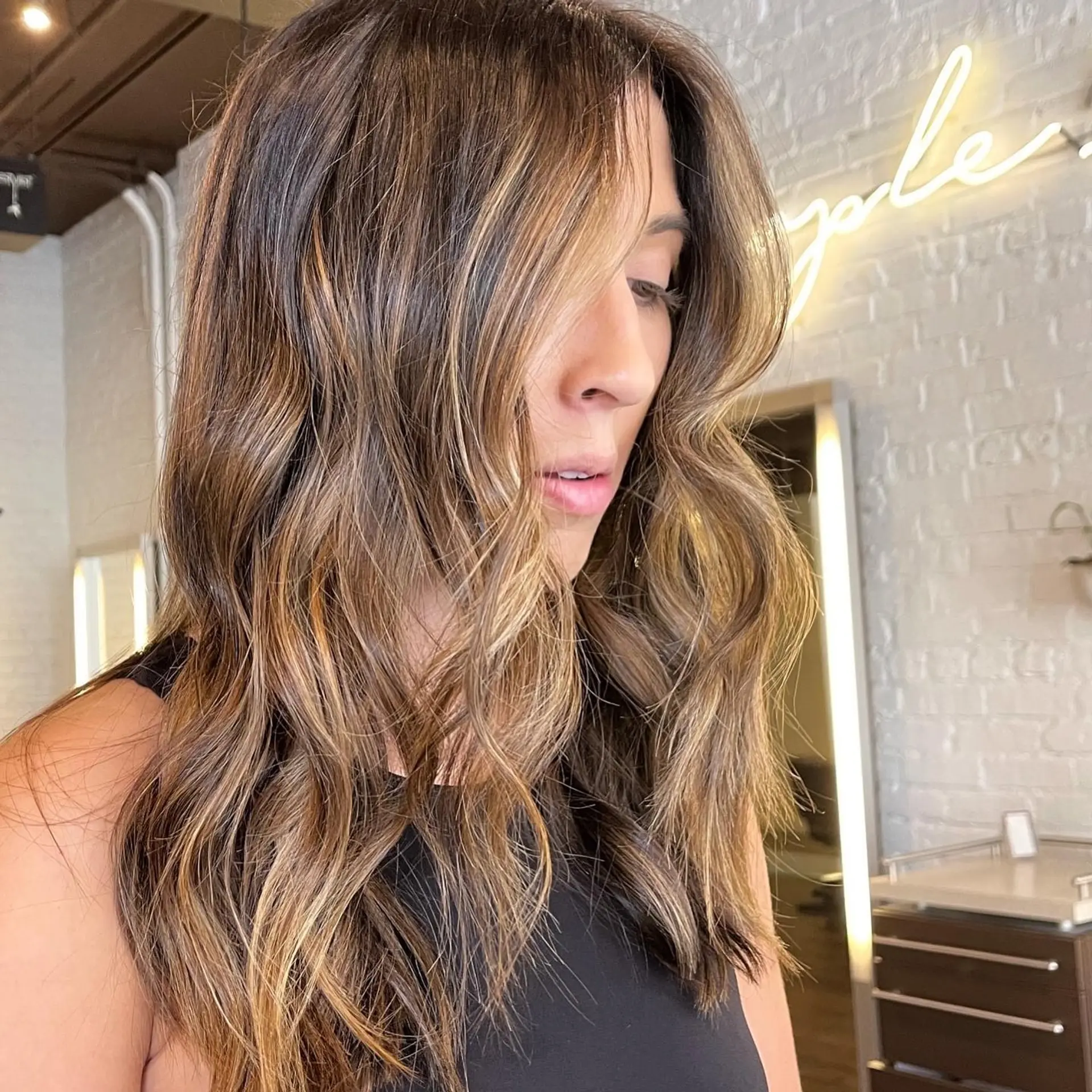 Medium length wavy hairstyle with bronzed balayage highlights. 1
