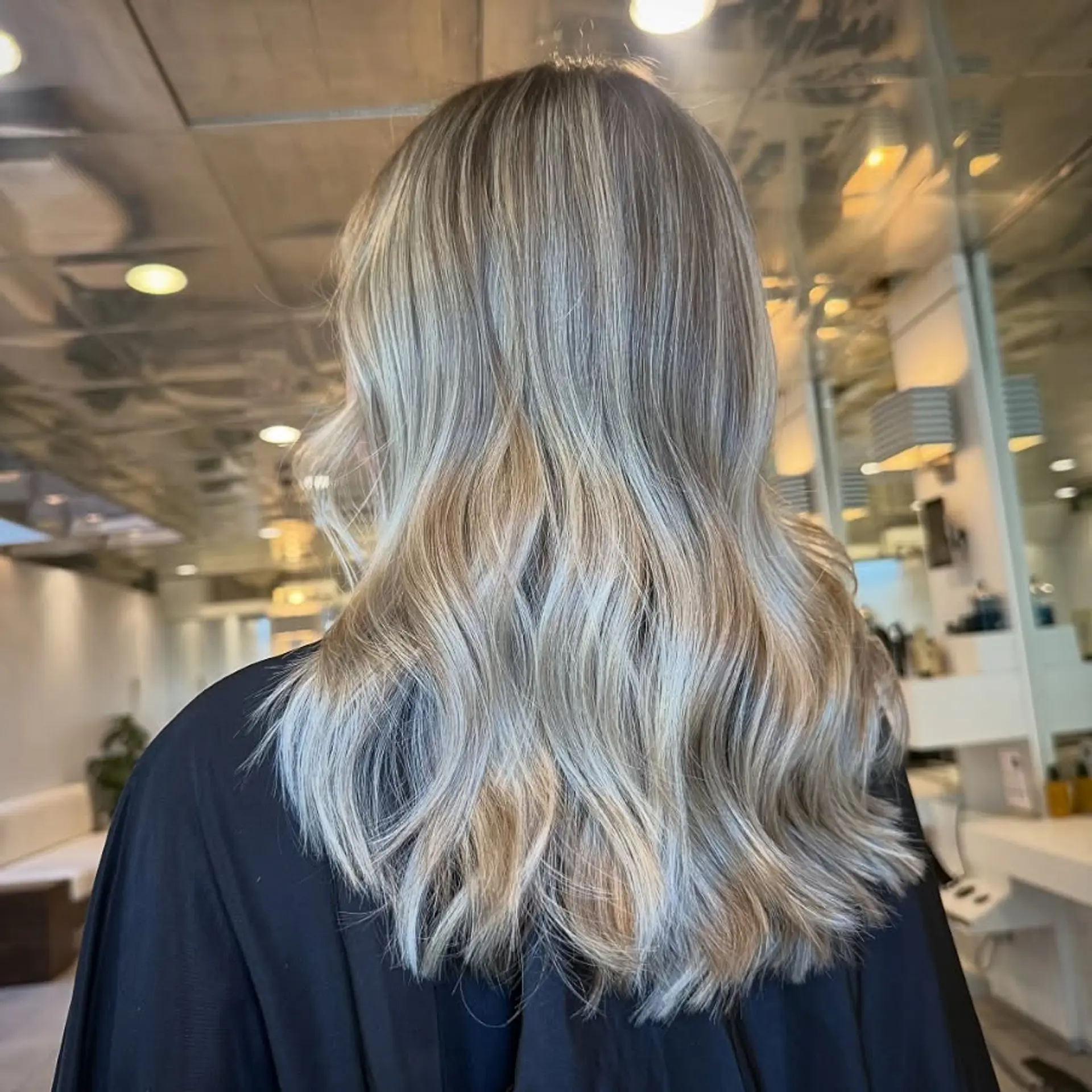 Long cool-toned blonde hair with seamless highlights, styled in soft waves. 1