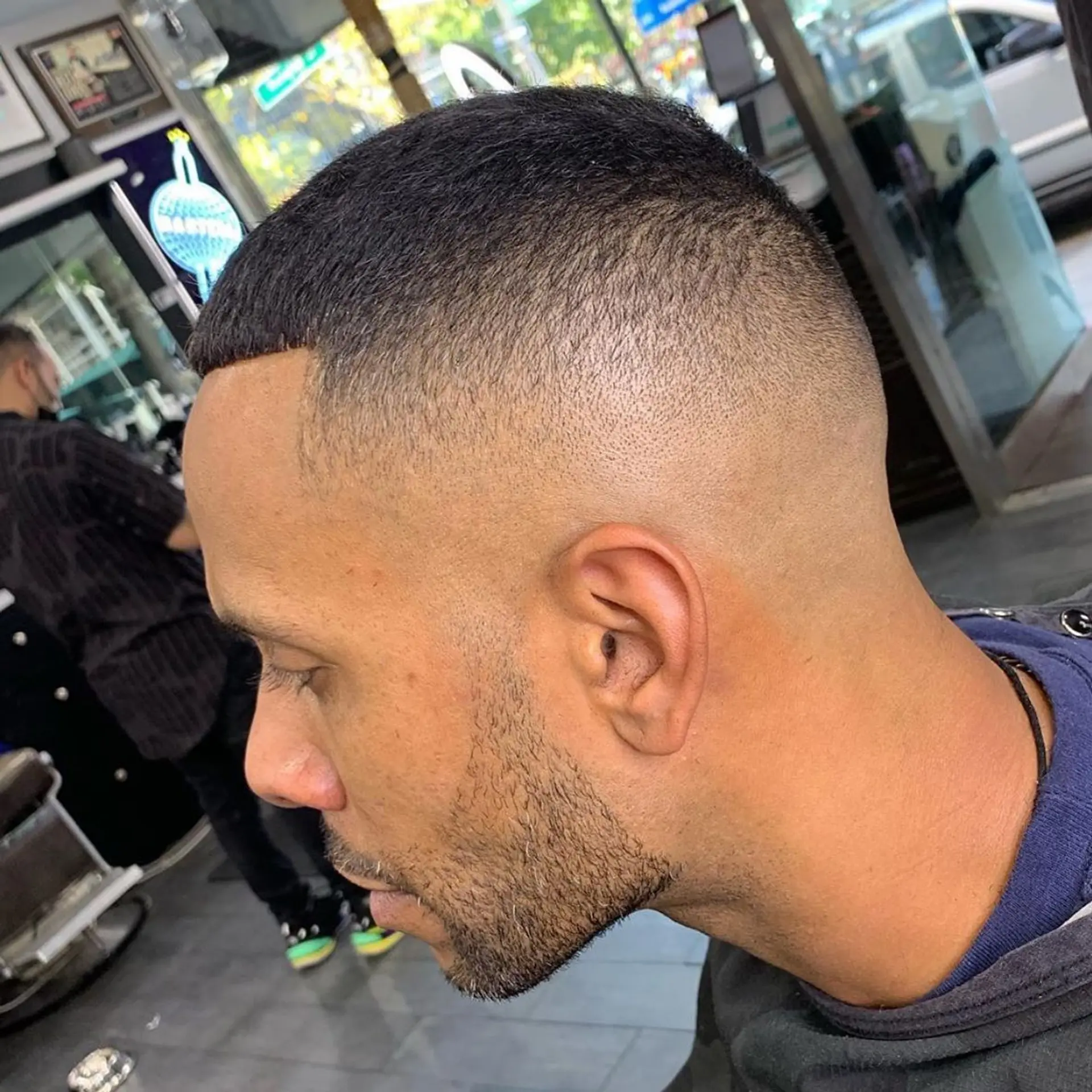 A sharp high skin fade blended into a short buzz cut on top with a clean lineup. 1