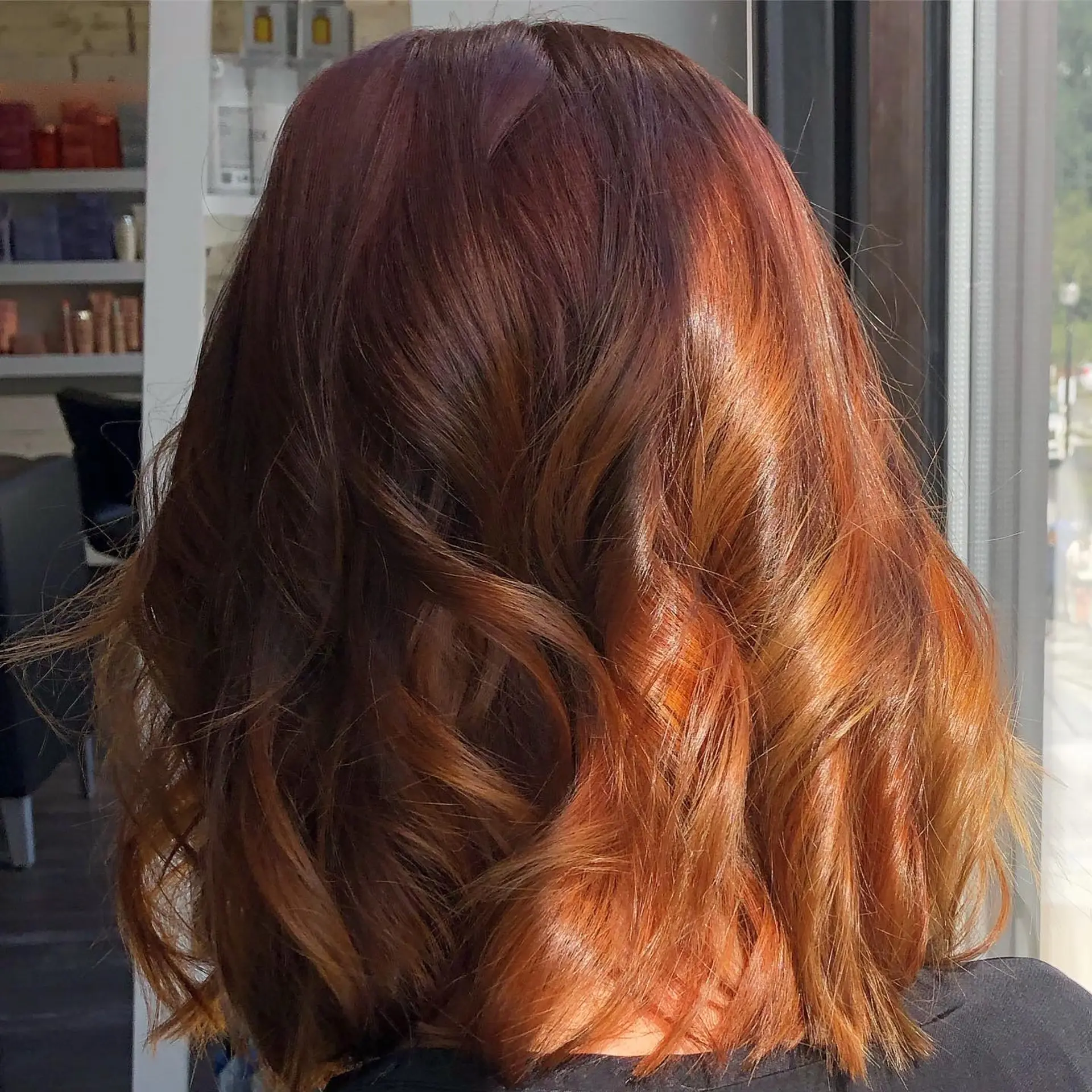 Shoulder-length textured lob styled in soft, loose waves showing off rich, multi-dimensional warm auburn and copper tones. 1