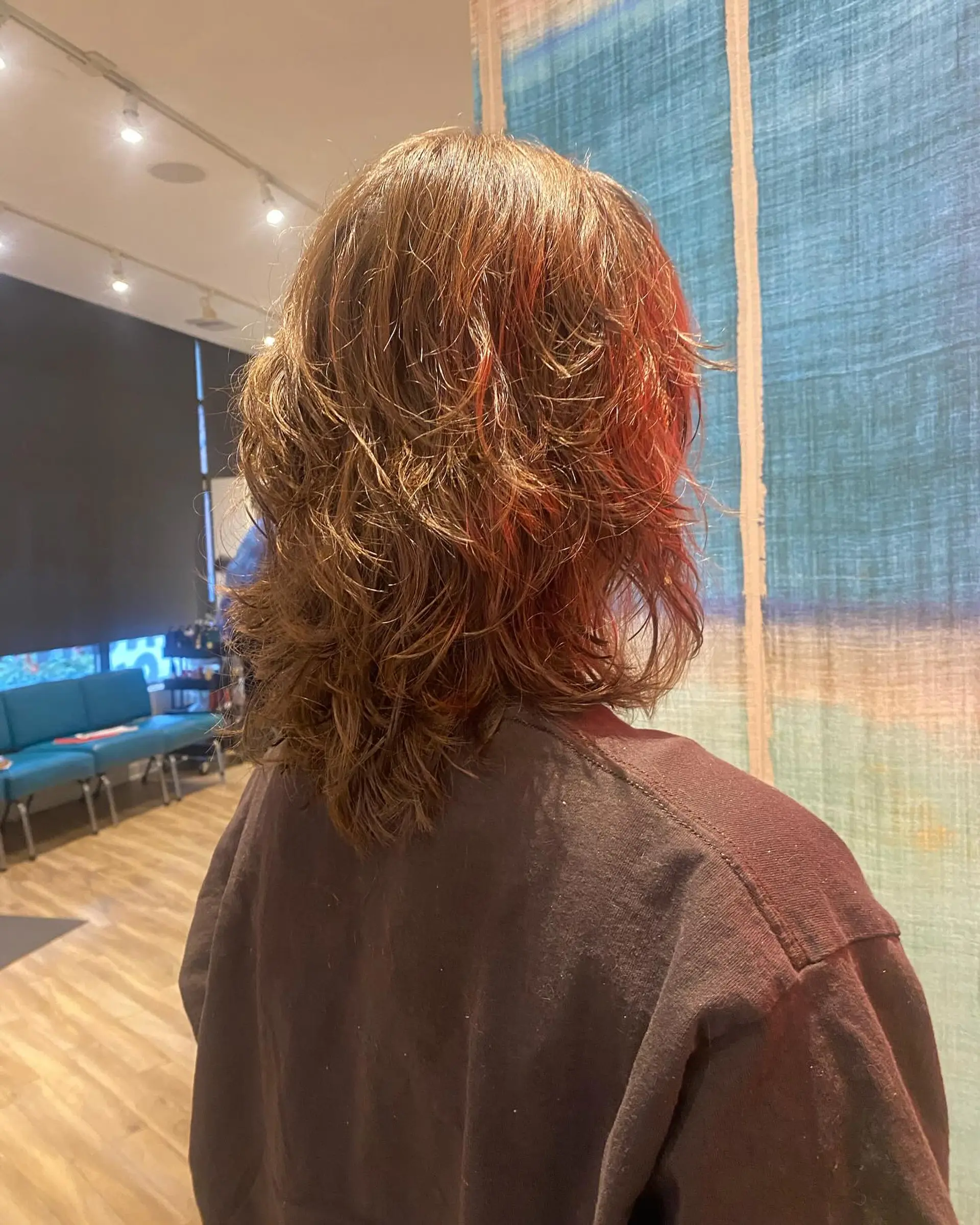 This is a medium-length curly shag with textured layers. The bronde color comes from a balayage. 2