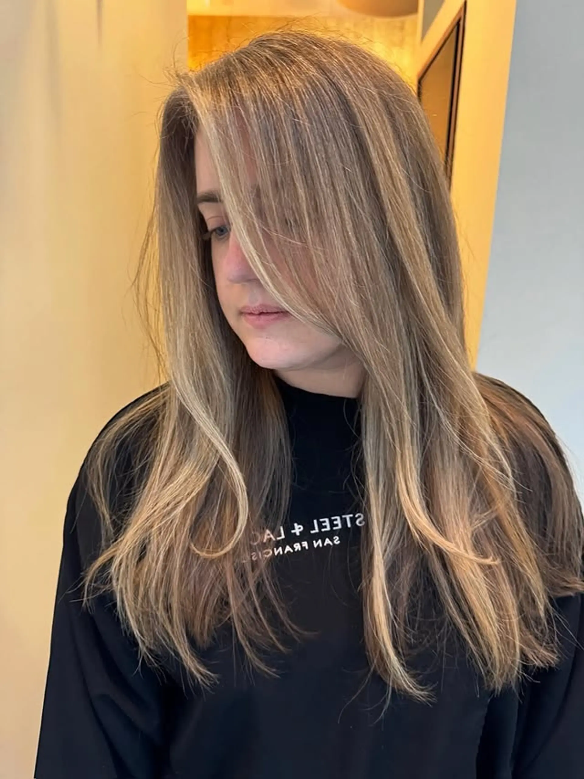 Long, layered bronde hair with face-framing layers and a balayage effect. 1