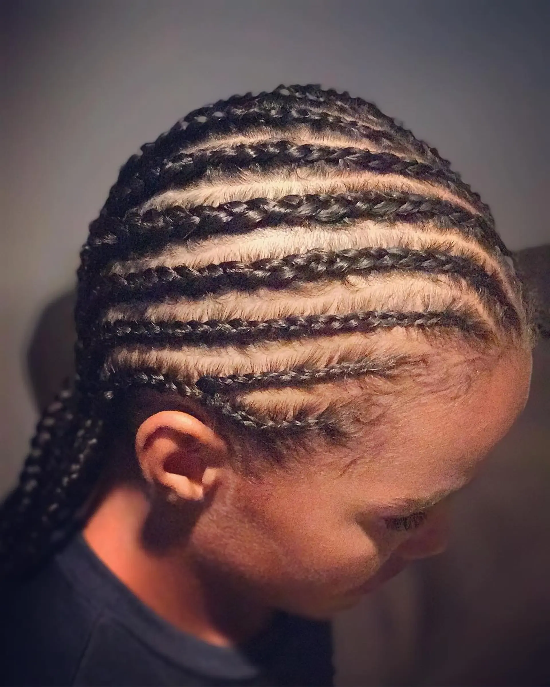 Neat, classic straight-back cornrow braids braided closely to the scalp and falling back. 1