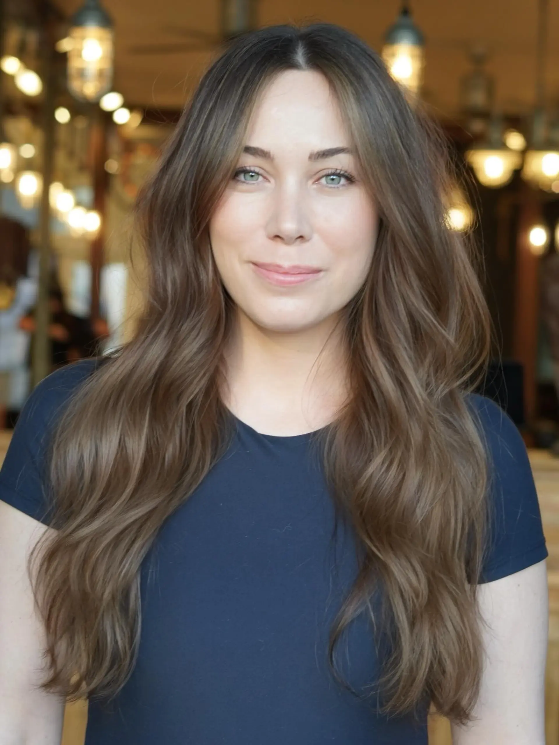 Long brunette hair styled in soft, natural waves with a center part and subtle dimensional highlights. 1