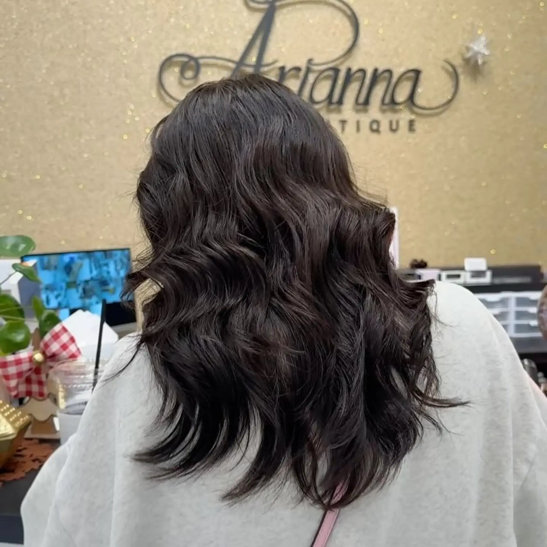Medium-length dark brown hair styled with soft, natural body waves from mid-lengths to ends. 1