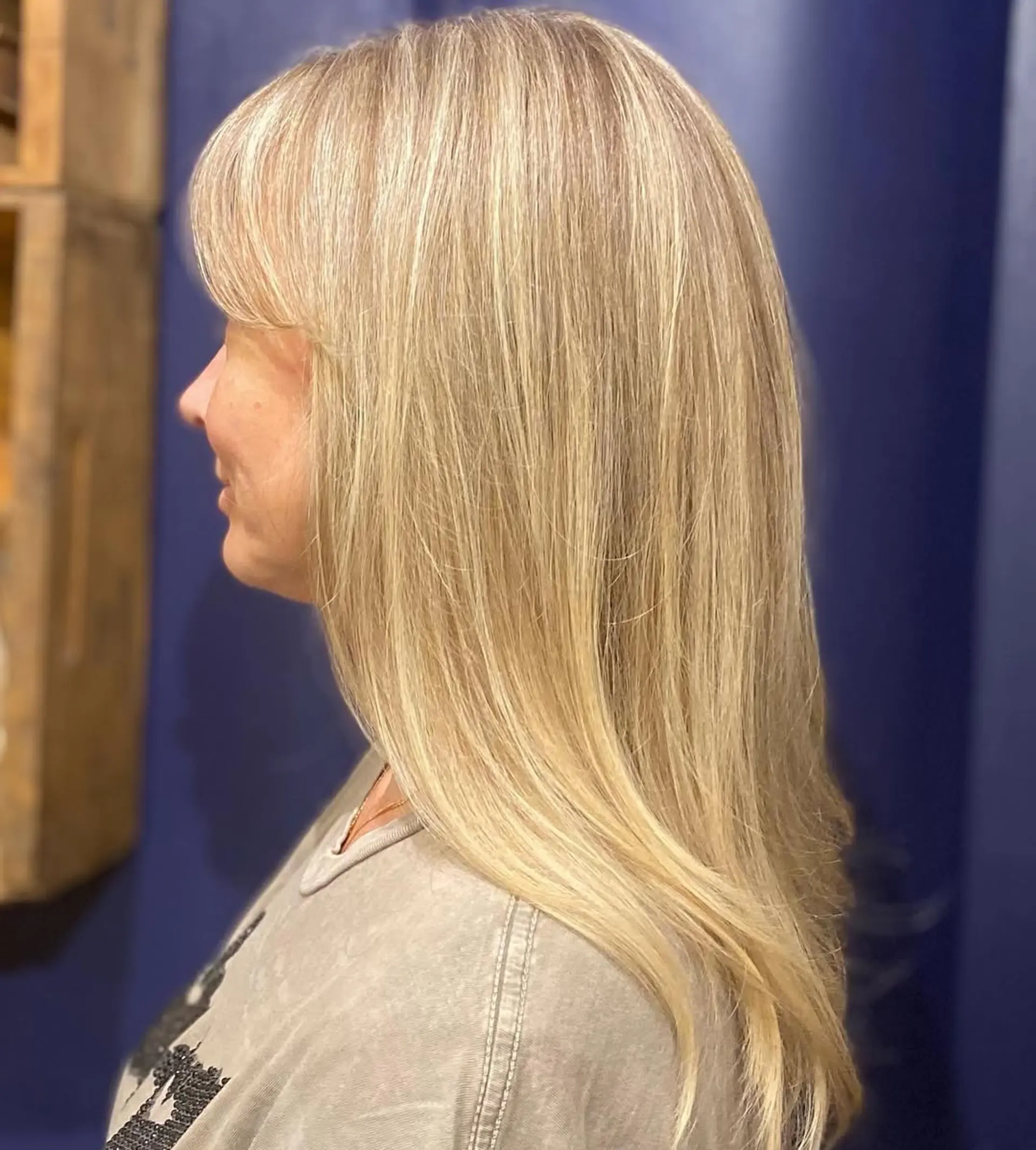 Long, straight blonde hair with honey tones, layered with side-swept bangs. 2