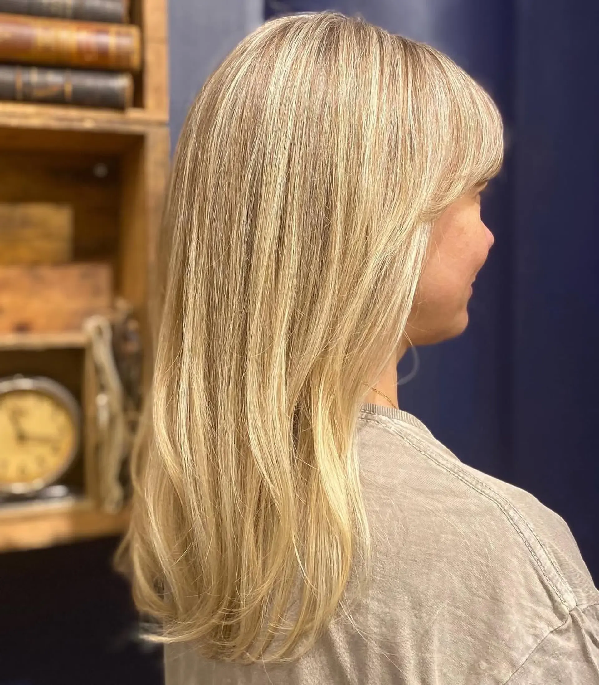 Long, straight blonde hair with honey tones, layered with side-swept bangs. 1