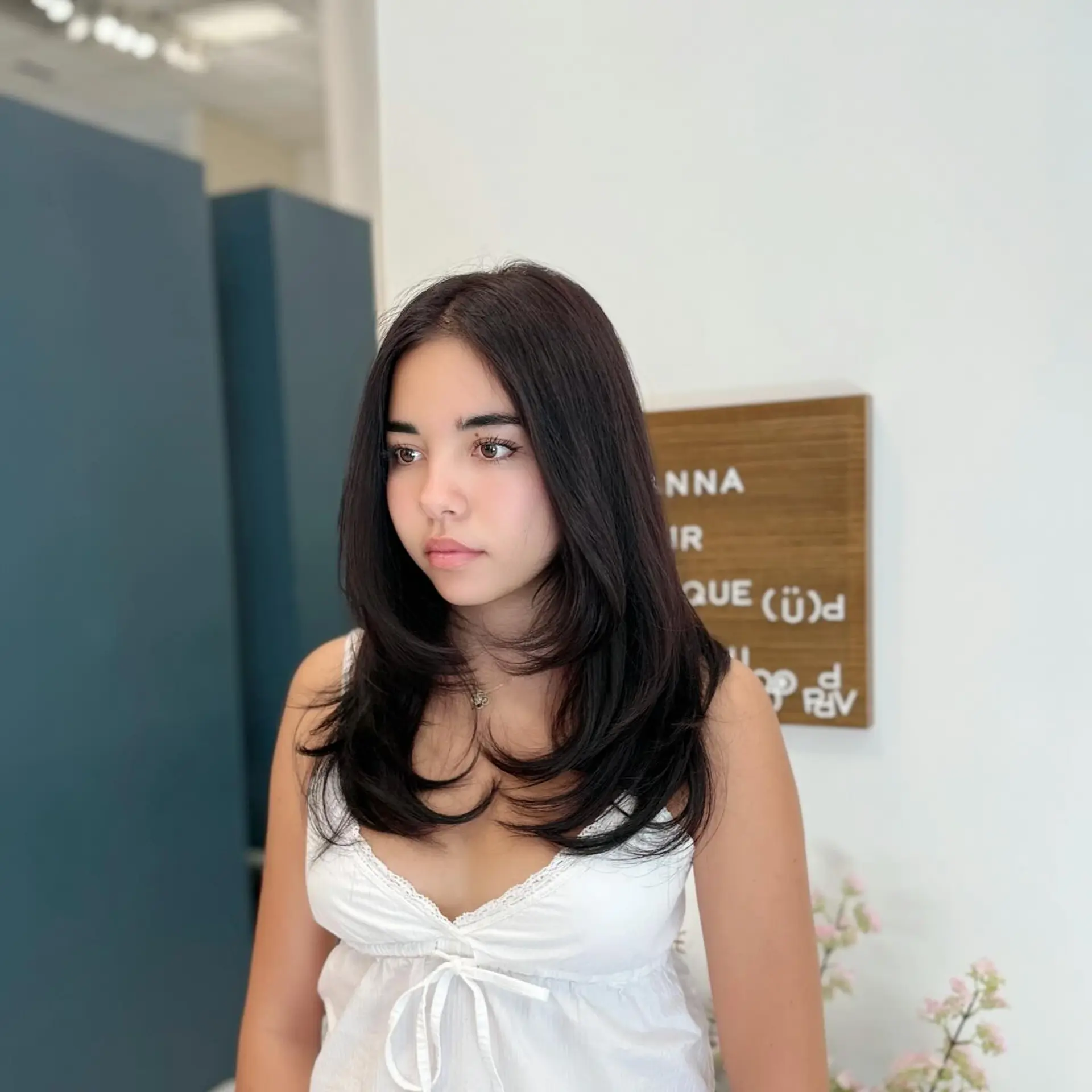 Medium to long dark hair styled with soft, cascading layers and curved face-framing ends. 1