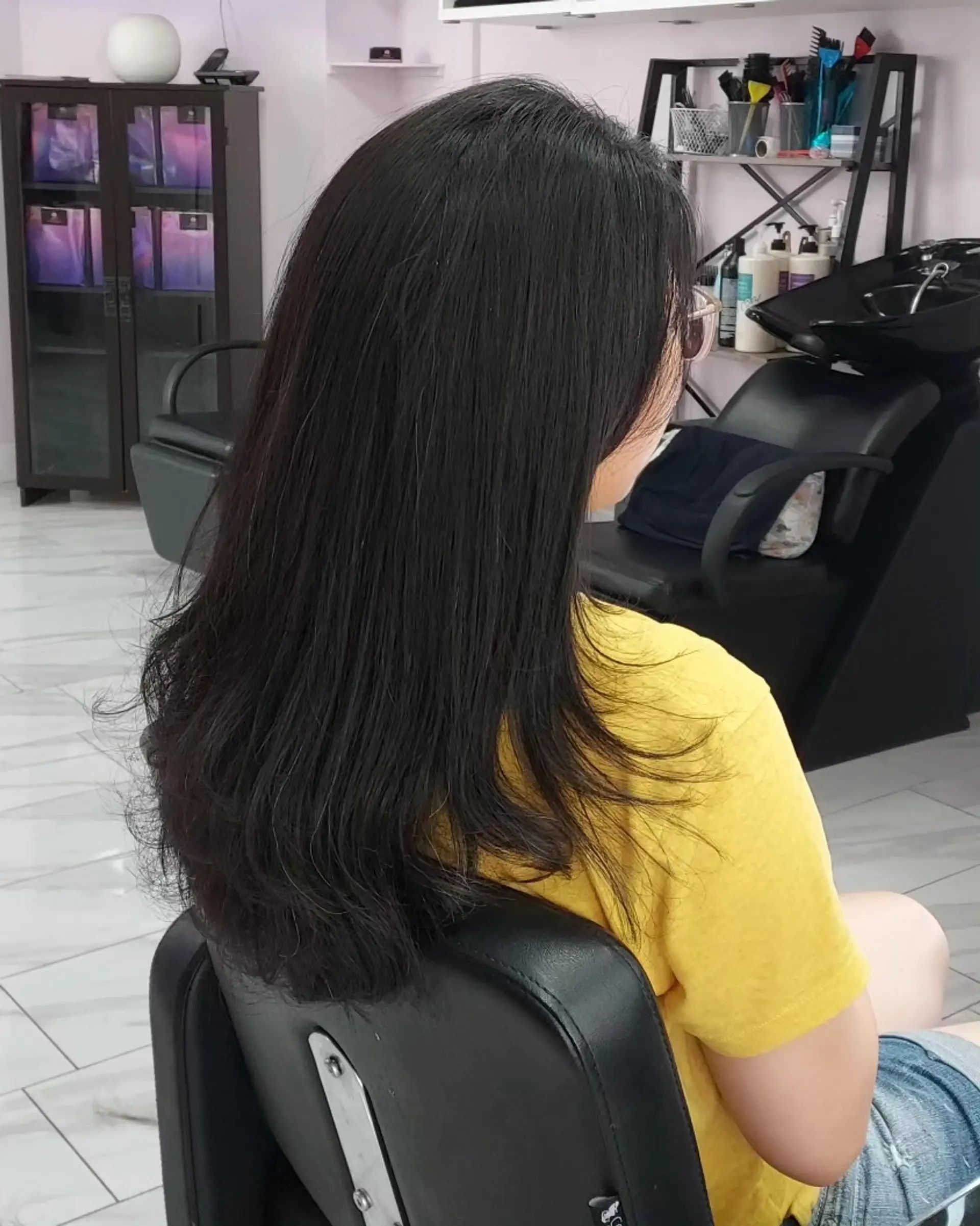 Mid-back length natural black hair cut with soft interior layering and slightly flipped, textured ends. 1