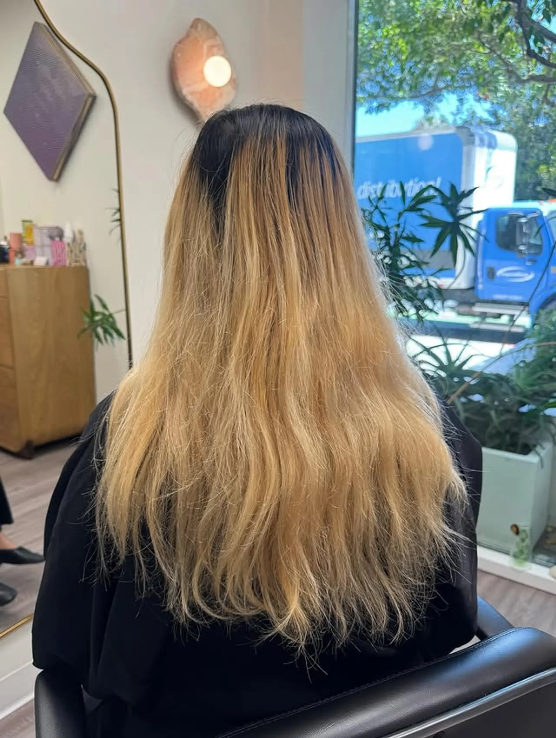 A long, straight hairstyle featuring a balayage that transitions from dark roots to a light blonde. 1