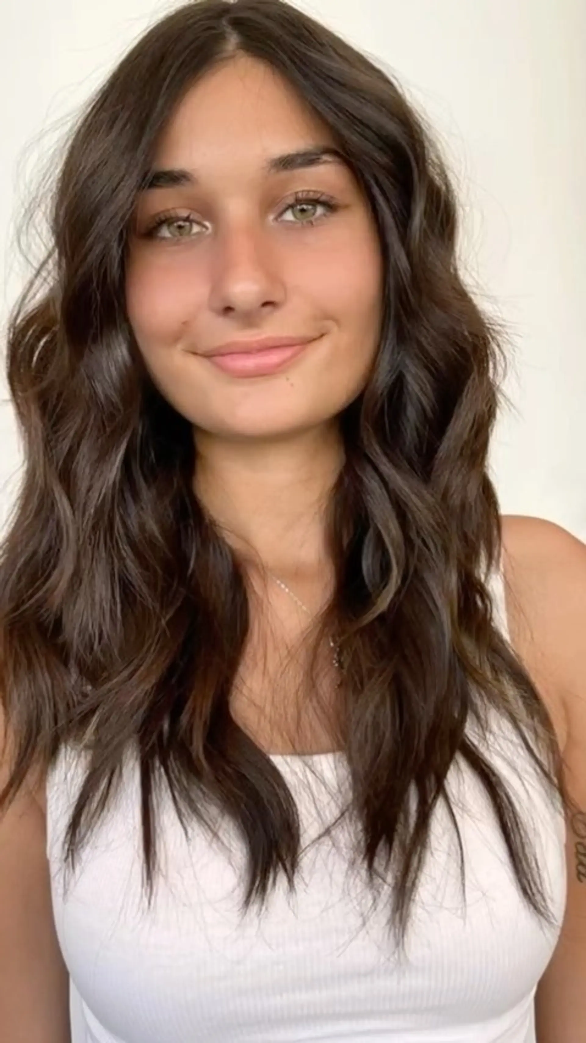 Long, rich chocolate brown hair cut with soft textured layers and styled into relaxed, tousled waves. 1