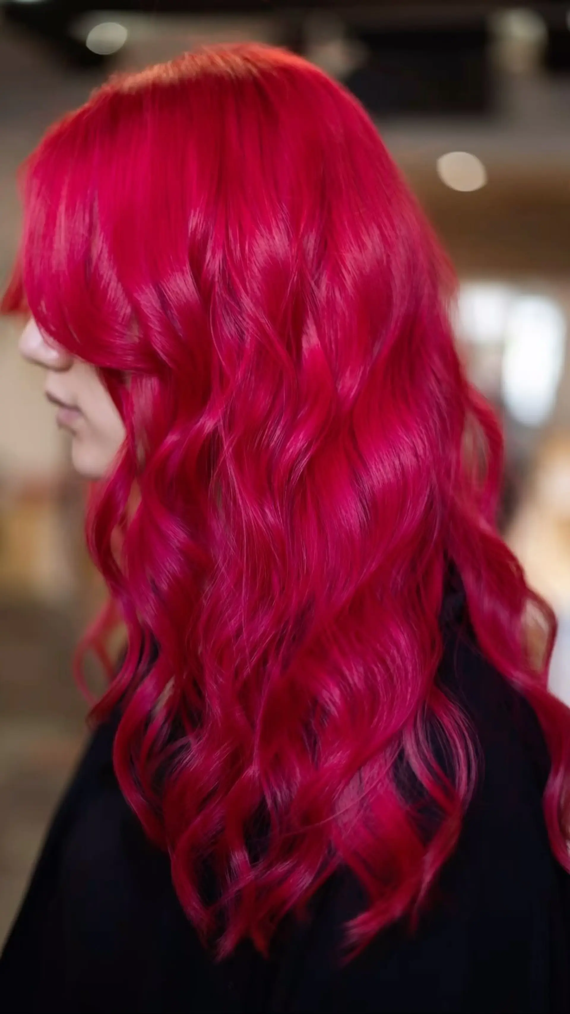 Long, flowing hair dyed in an intense, vibrant magenta-red tone, styled with soft and voluminous loose waves. 1