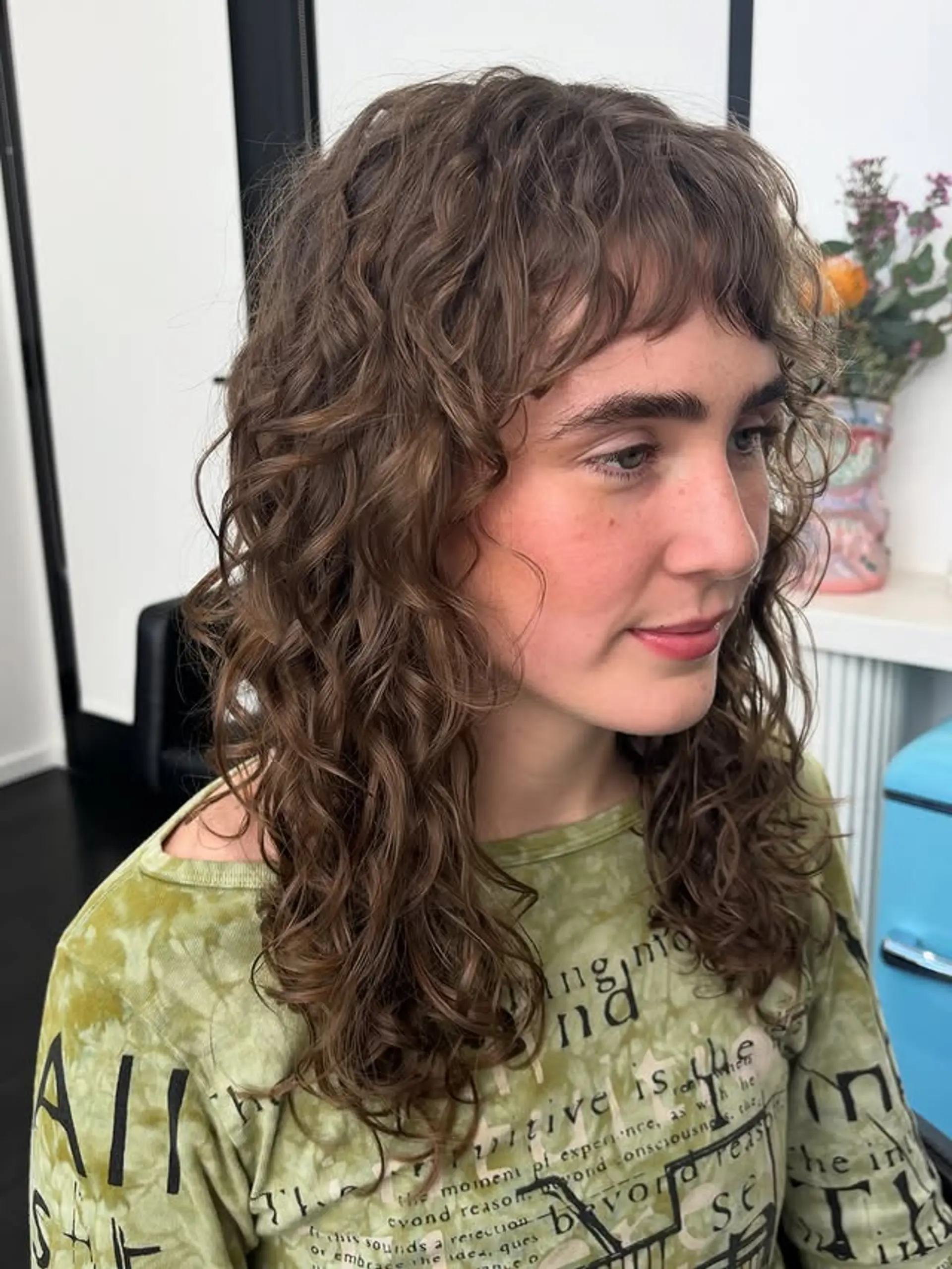 A trendy shag haircut with lots of textured layers and curly bangs. 1