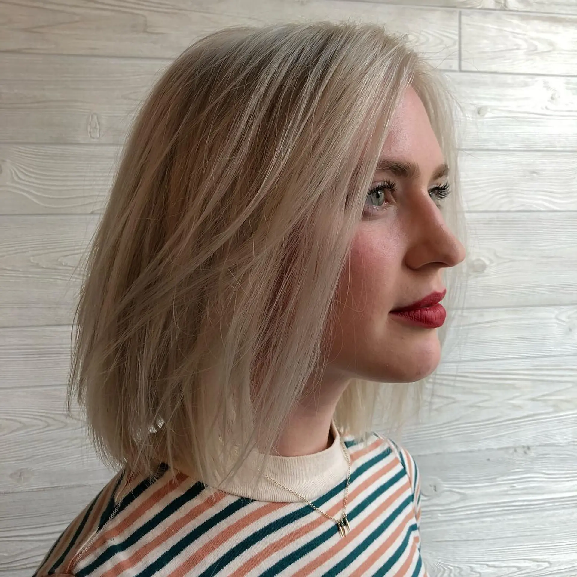 A sleek, textured collarbone-length lob colored in an all-over platinum ash blonde. 1