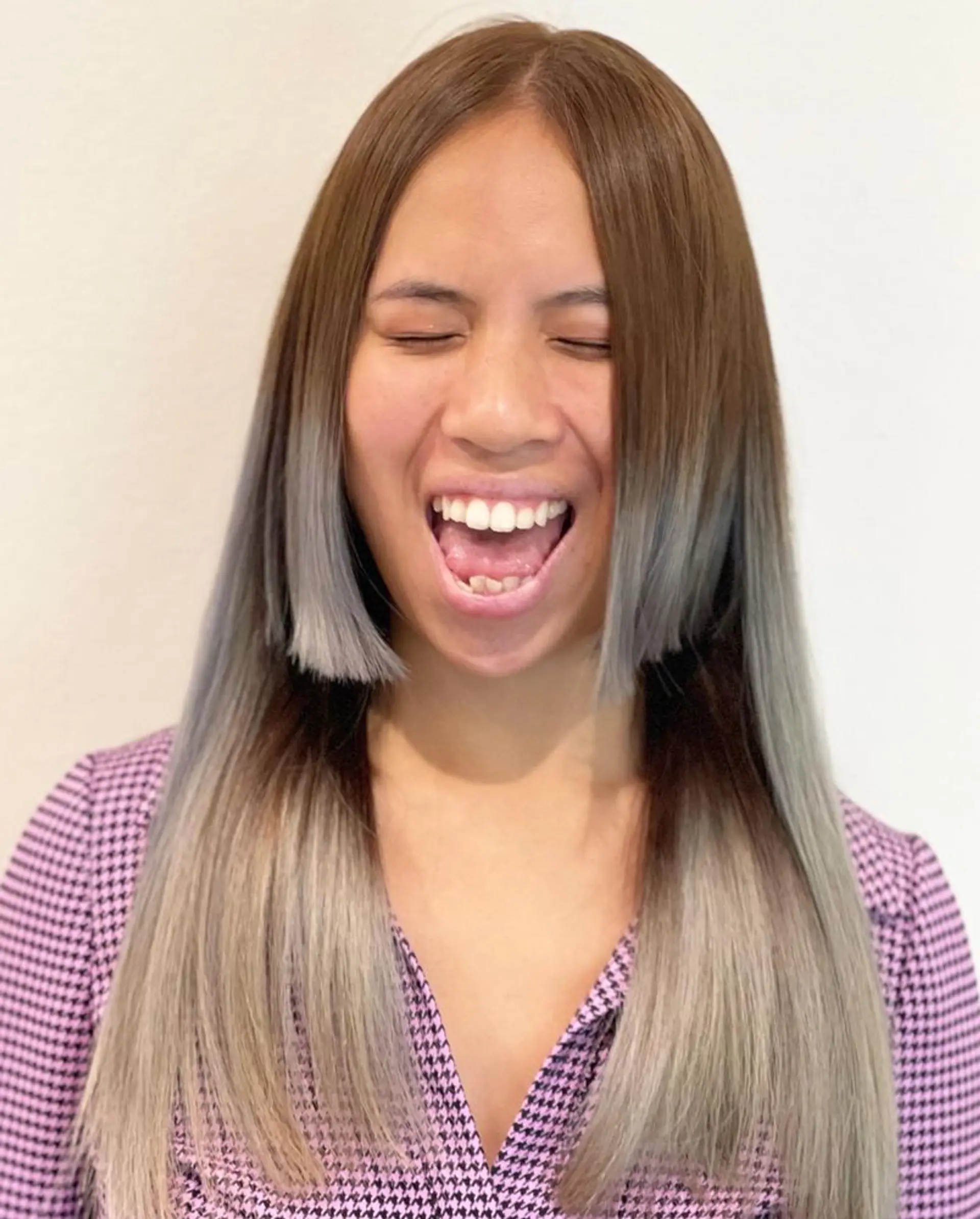 A long straight hairstyle with a brown to gray-blonde ombre and short, choppy bangs. 1