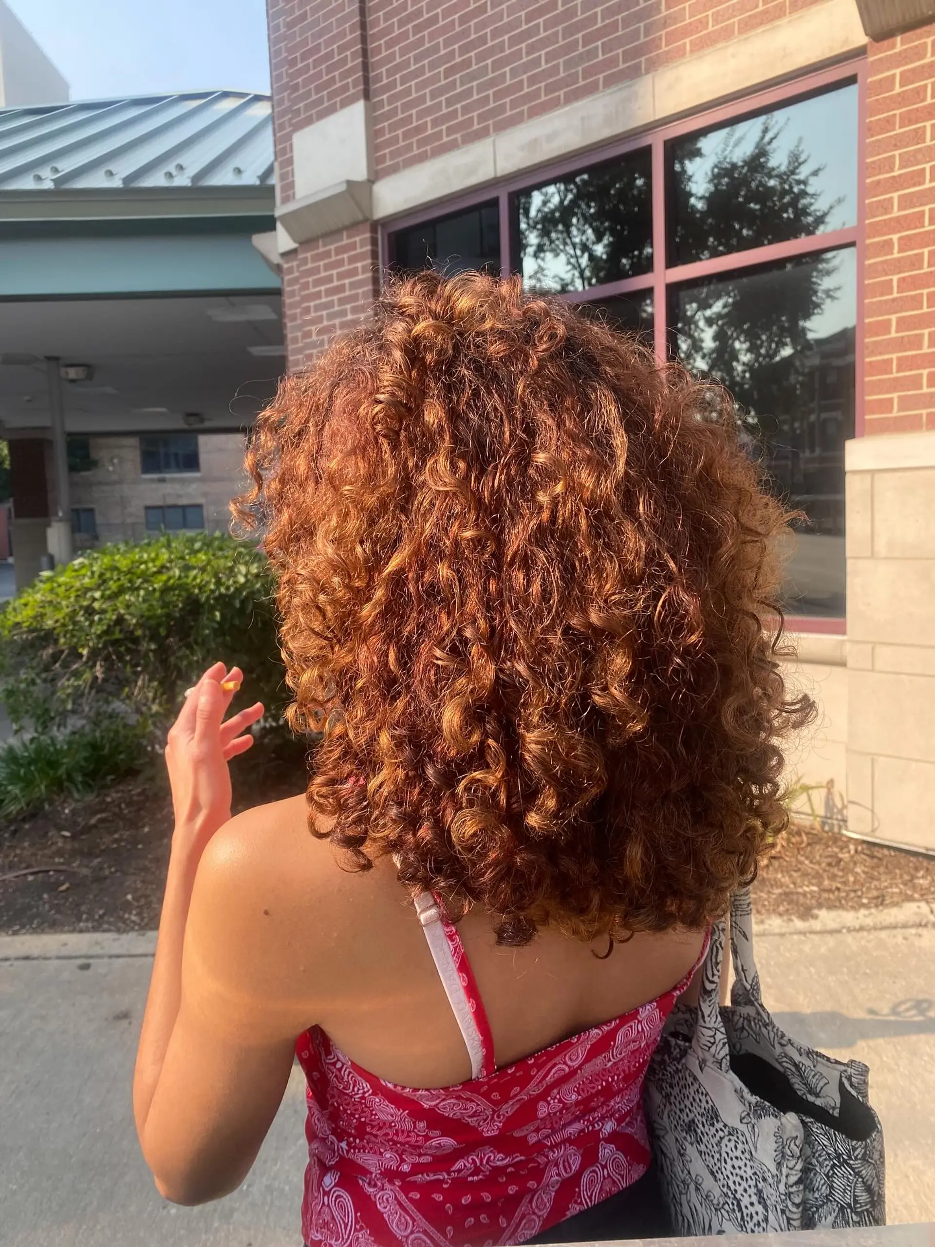 A stylish, medium-length bob with bouncy, defined curls and a rich copper color. 2