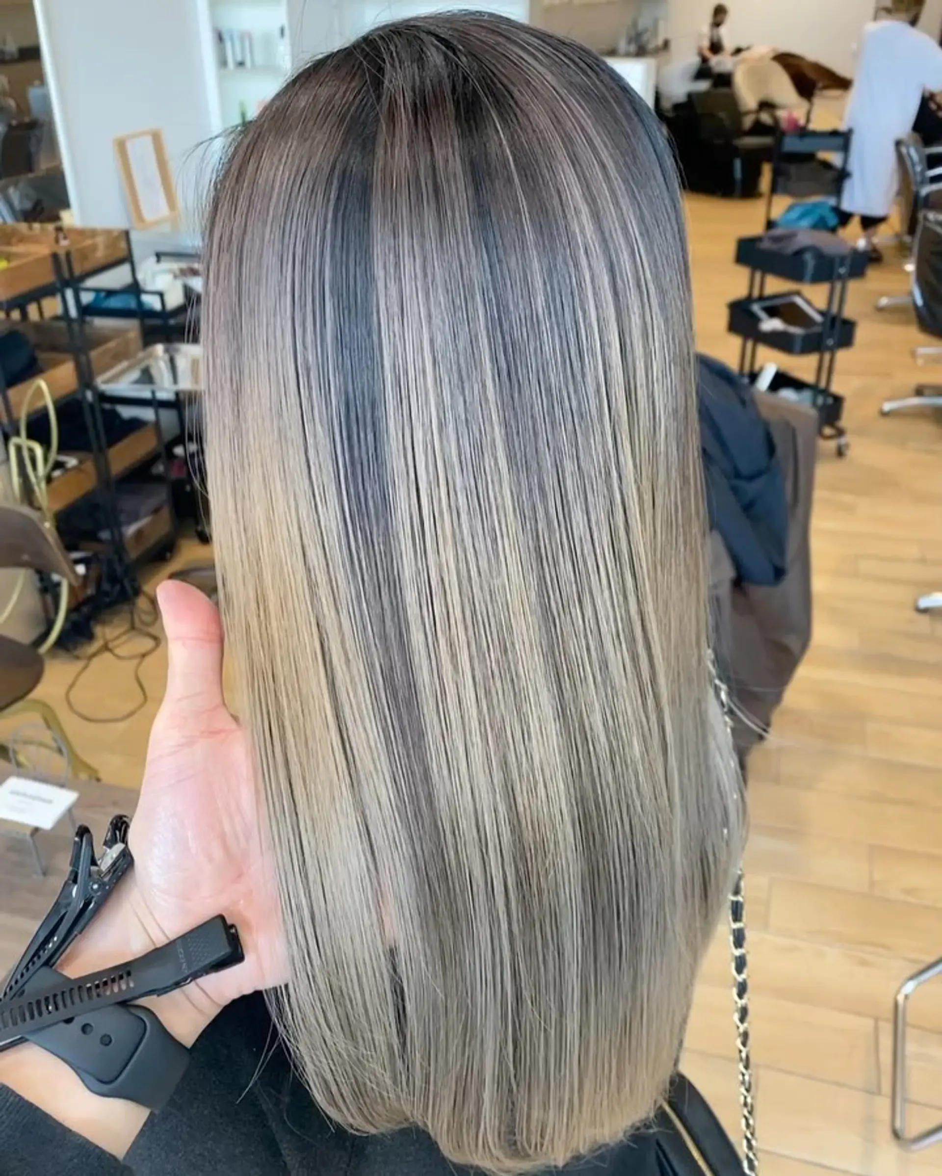 Straight, sleek long hair showcasing a seamless cool ash blonde balayage with dark root blending. 1