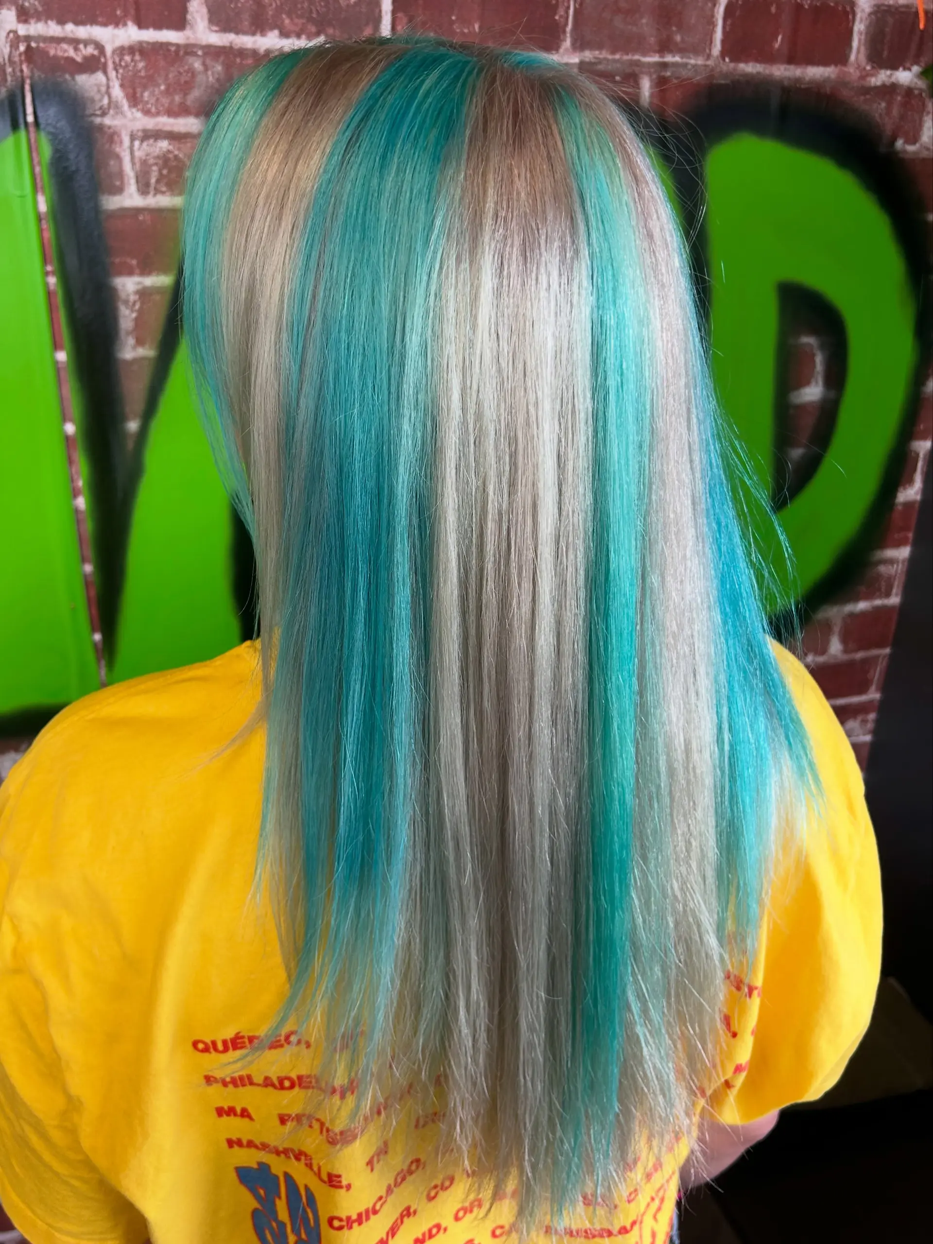 Straight, long hair featuring bold chunky streaks of vibrant teal contrasting against platinum blonde locks. 1