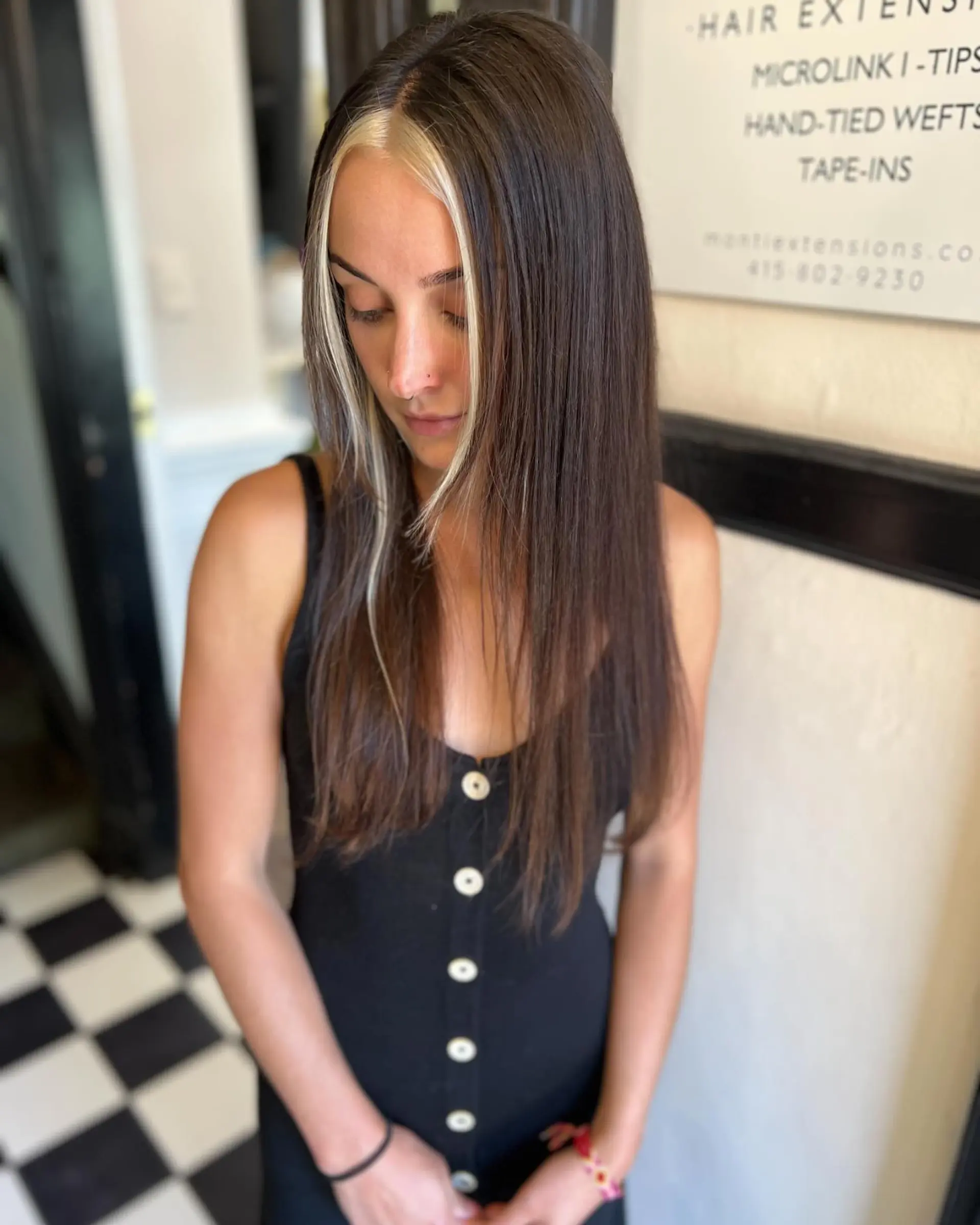 Straight, long dark brown hair styled with bright blonde face-framing money piece strands. 1