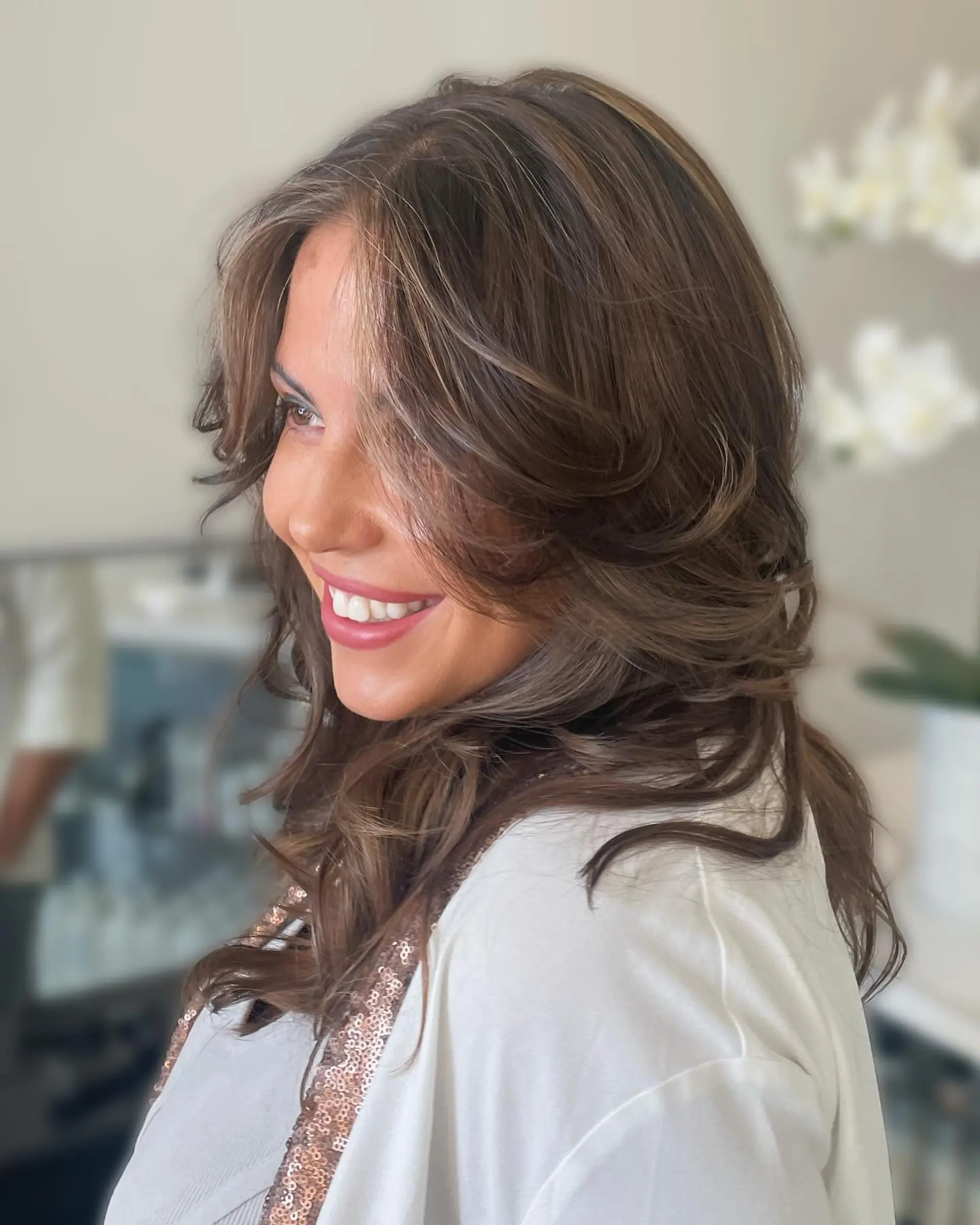 A voluminous layered blowout featuring soft face-framing curtain layers with dimensional highlights and lowlights. 1