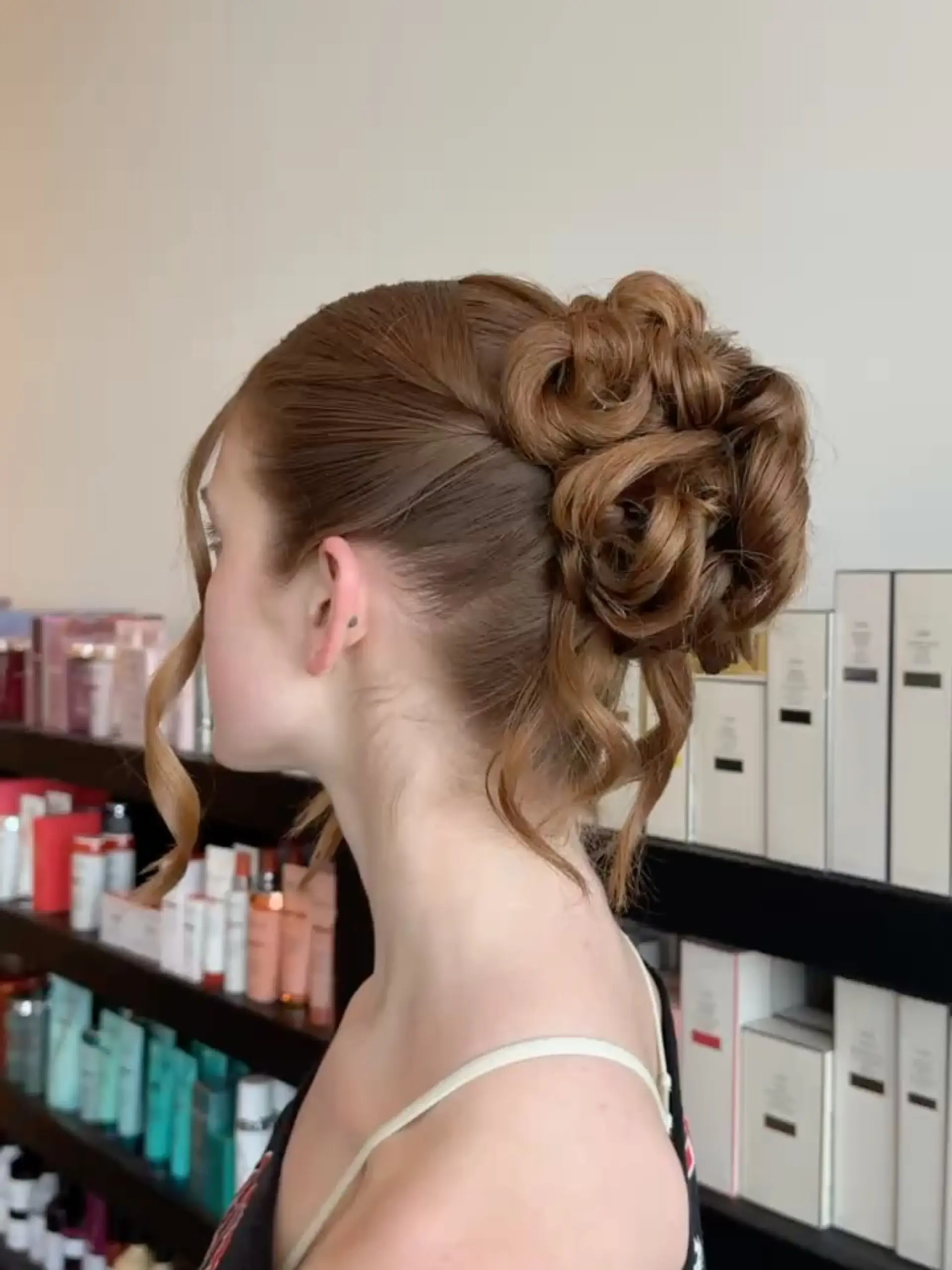 A sophisticated formal updo arranged into sculpted floral rosette curls at the back, accented by soft face-framing tendrils. 1