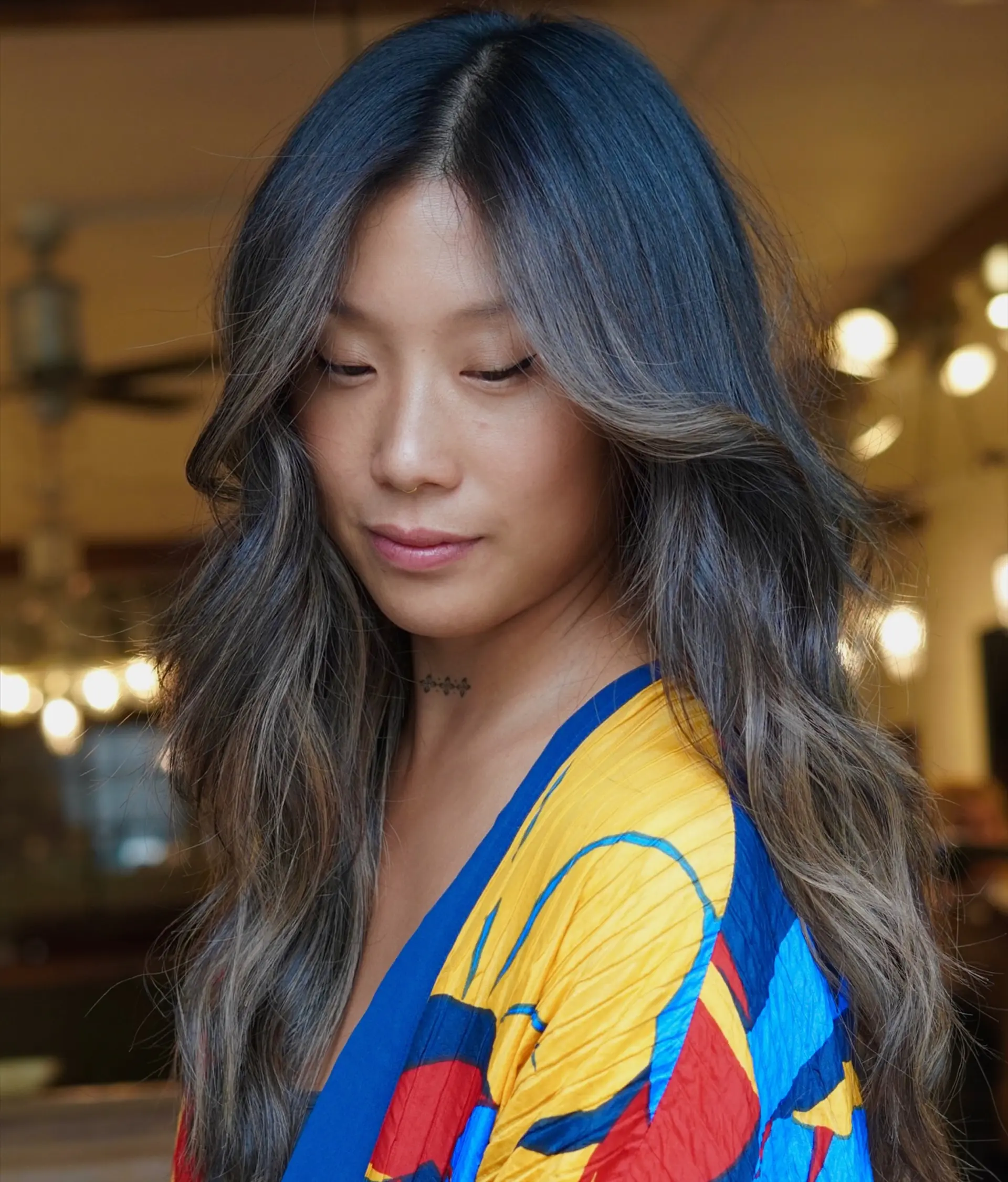 Long layered brunette hair with seamless, cool-toned lived-in balayage highlights styled in soft, cascading waves. 1