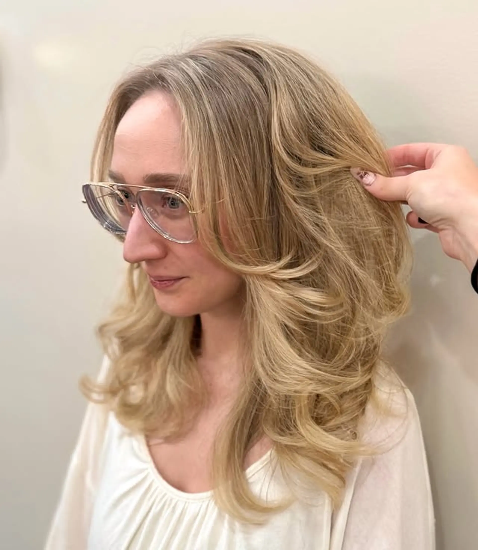 Long, wavy hairstyle with a 70s-inspired layered cut and curtain bangs. 1