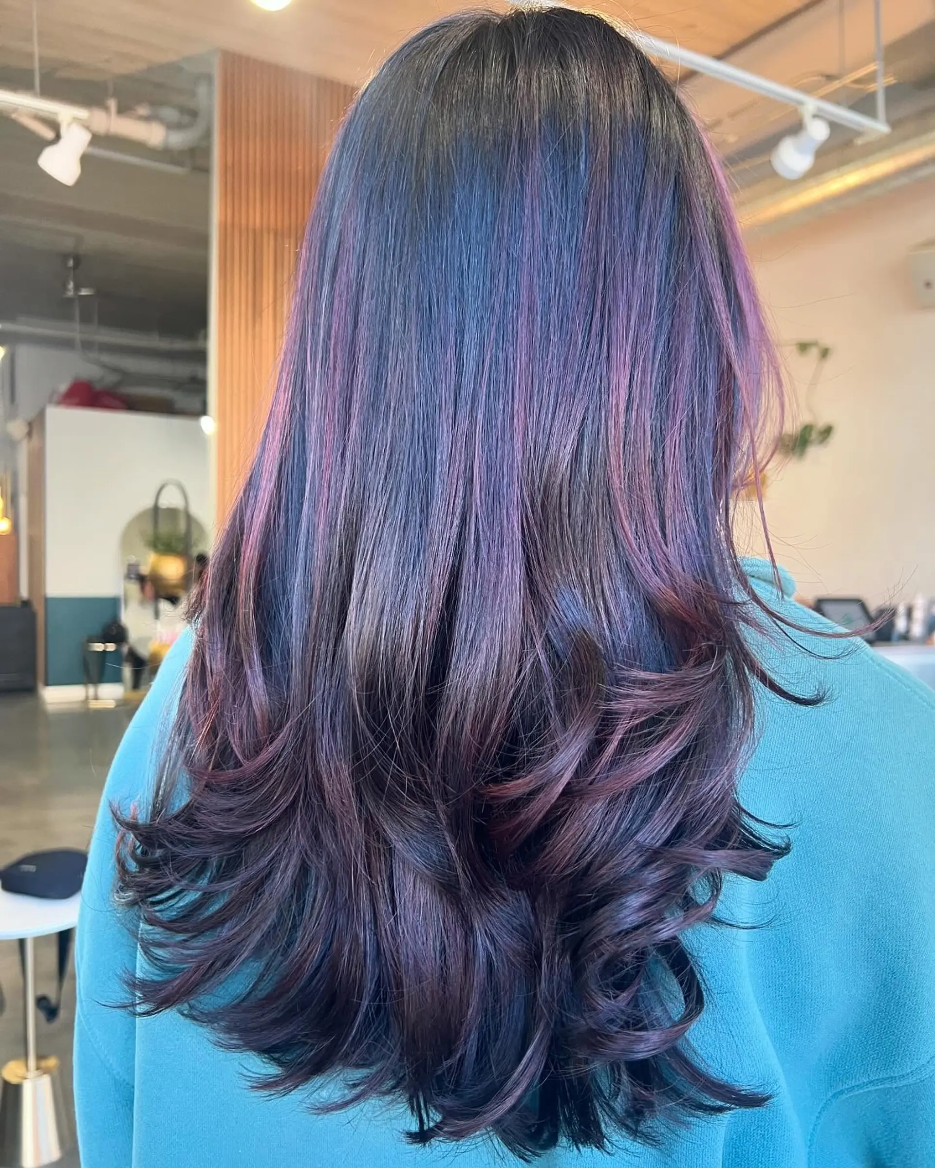Long, layered hair with amethyst and purple highlights and soft waves at the ends. 1