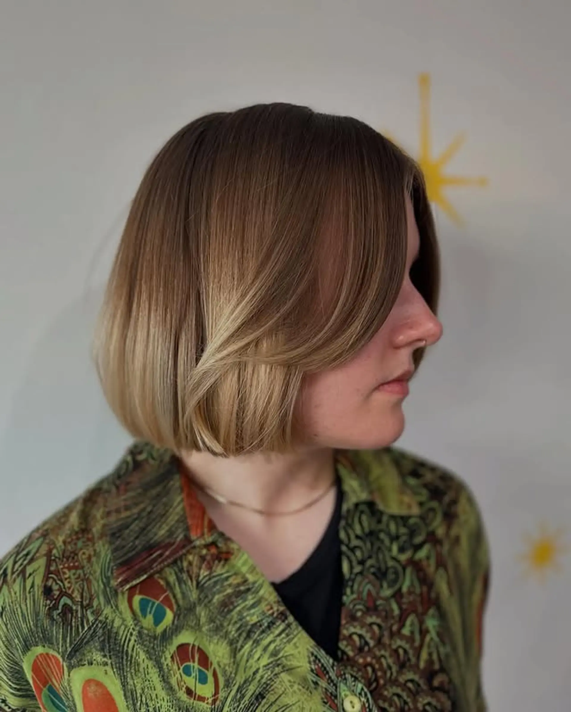 A trendy shoulder-length bob with face-framing layers and a bronde color melt. 1