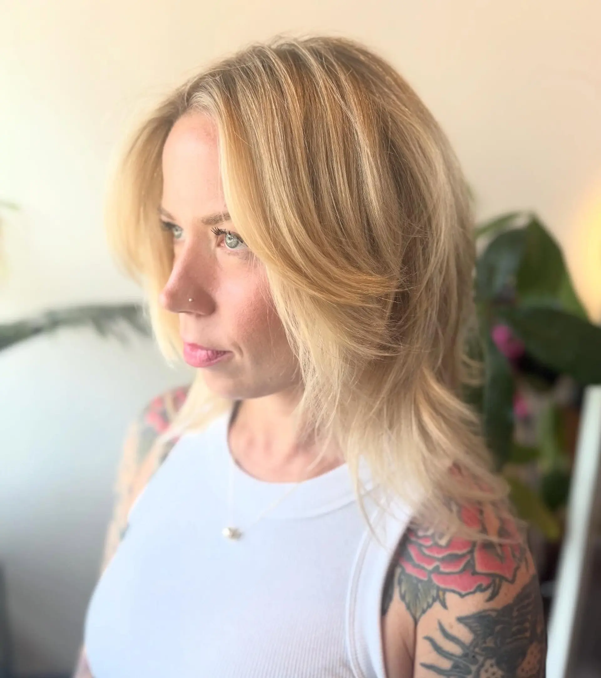 Medium-length bright blonde shag cut featuring feathered curtain bangs and soft, face-framing layers. 1