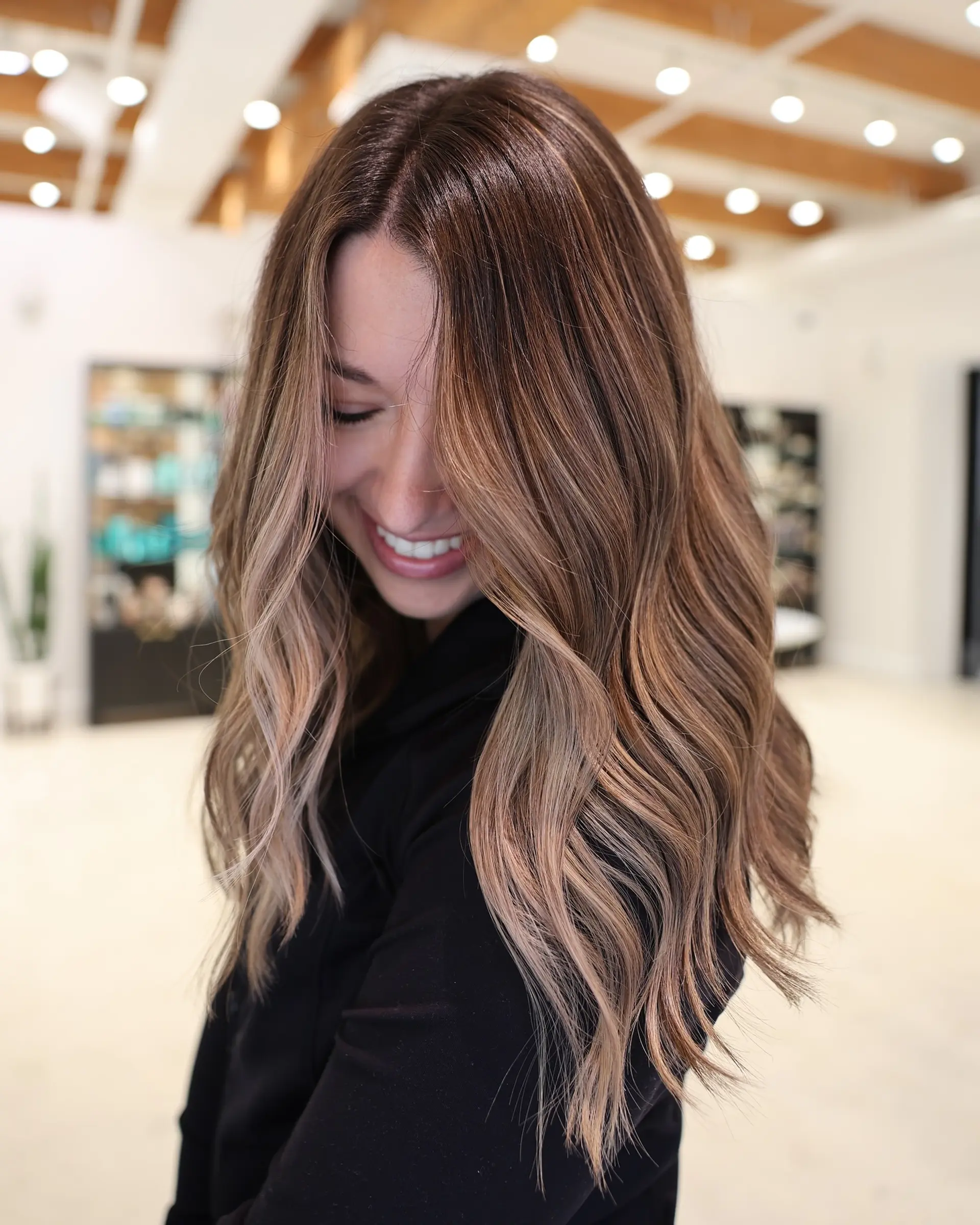 A long, layered cut with a bronde balayage, creating a soft, wavy and dimensional style. 1