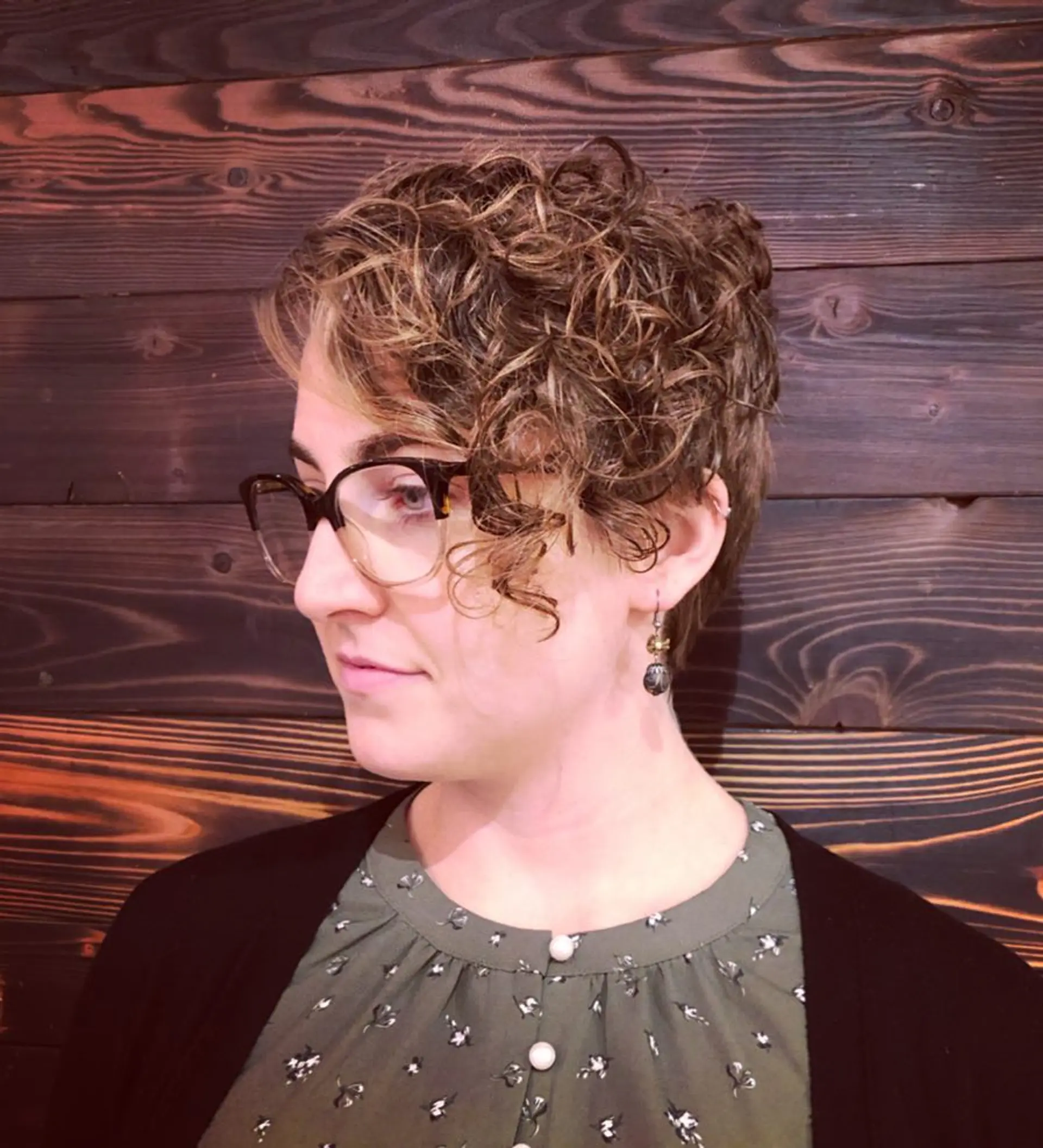 A short, curly pixie cut with highlights for added dimension and texture. 1