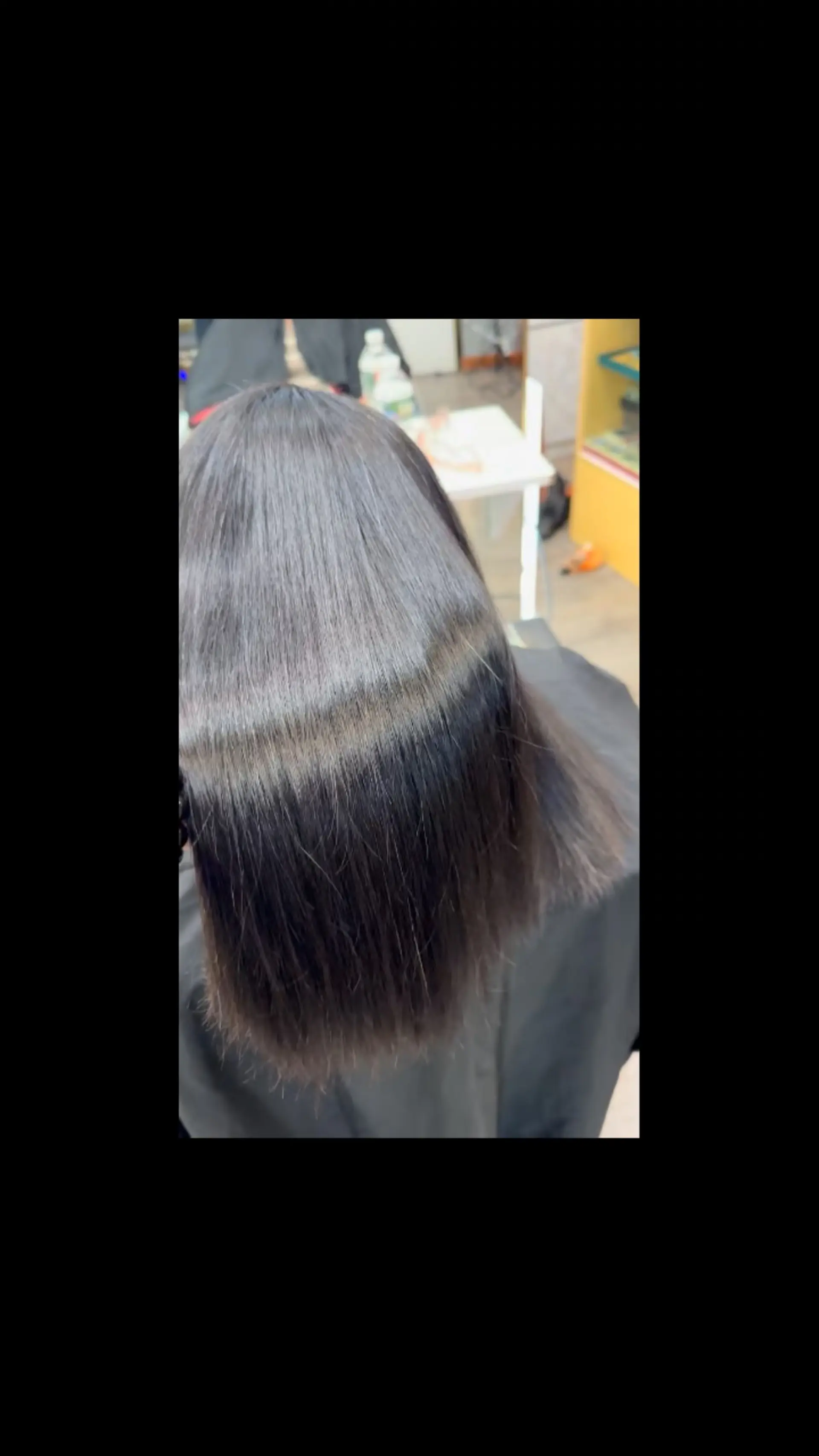Medium-length dark hair styled into a smooth, glossy, bone-straight finish. 1