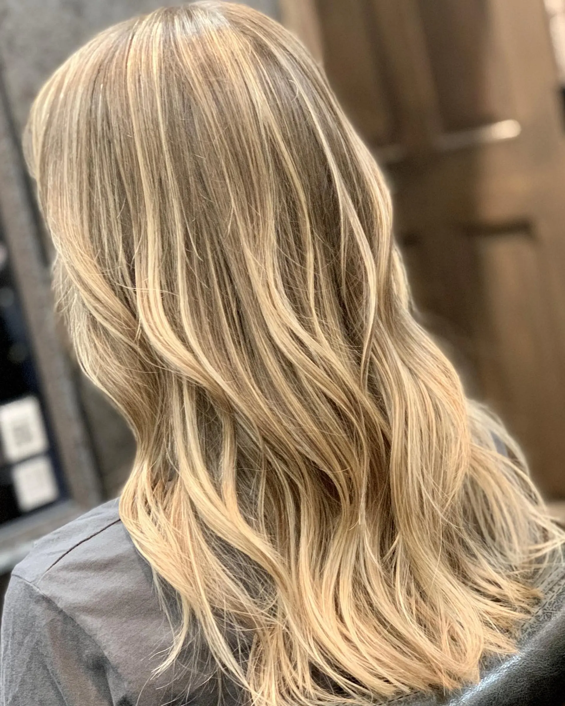 Long hair featuring a multi-dimensional beige blonde balayage styled with soft, loose waves. 1