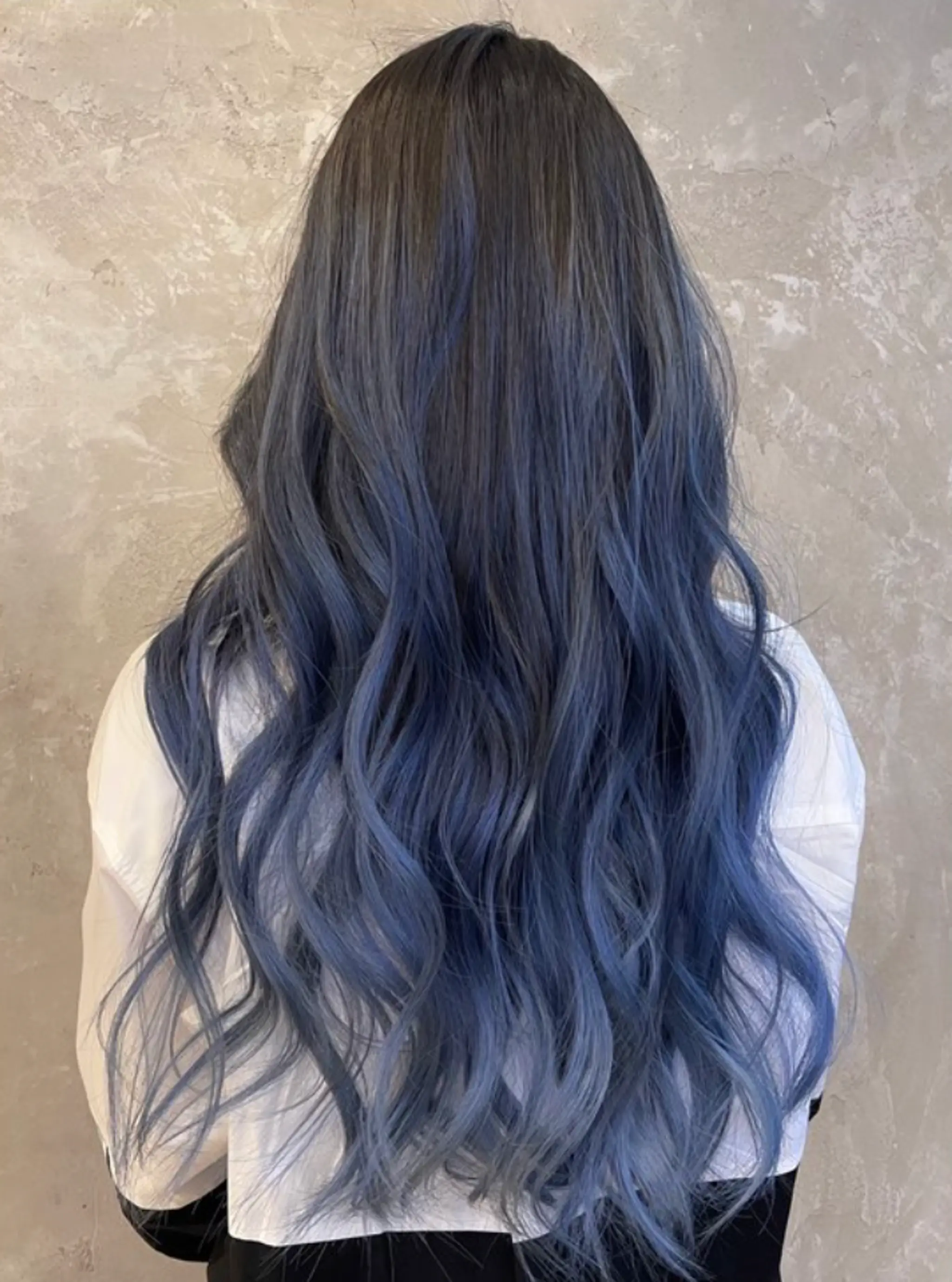 A stunning long, wavy hairstyle with an ombre color transition from dark gray to blue. The vivid blue tones and natural waves create a layered, voluminous effect.
(NonstopStyle: by Kelvin)