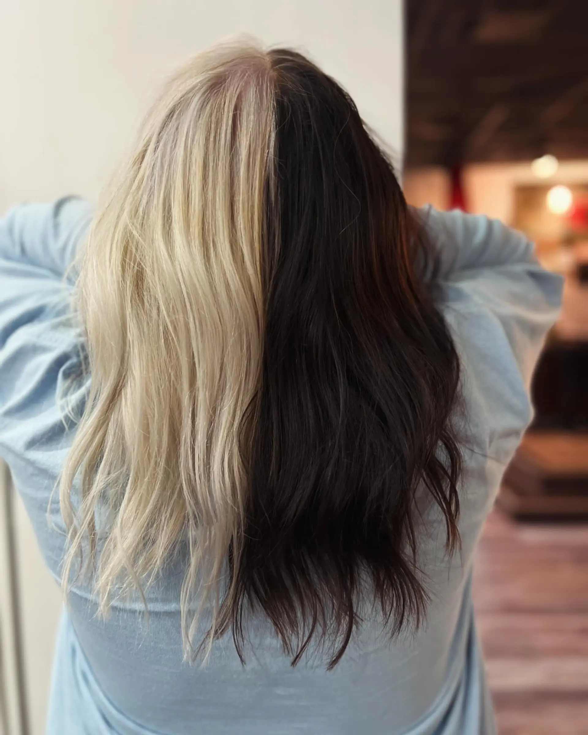 A bold split-dye style featuring clean division between platinum blonde on one half and deep brunette on the other. 1