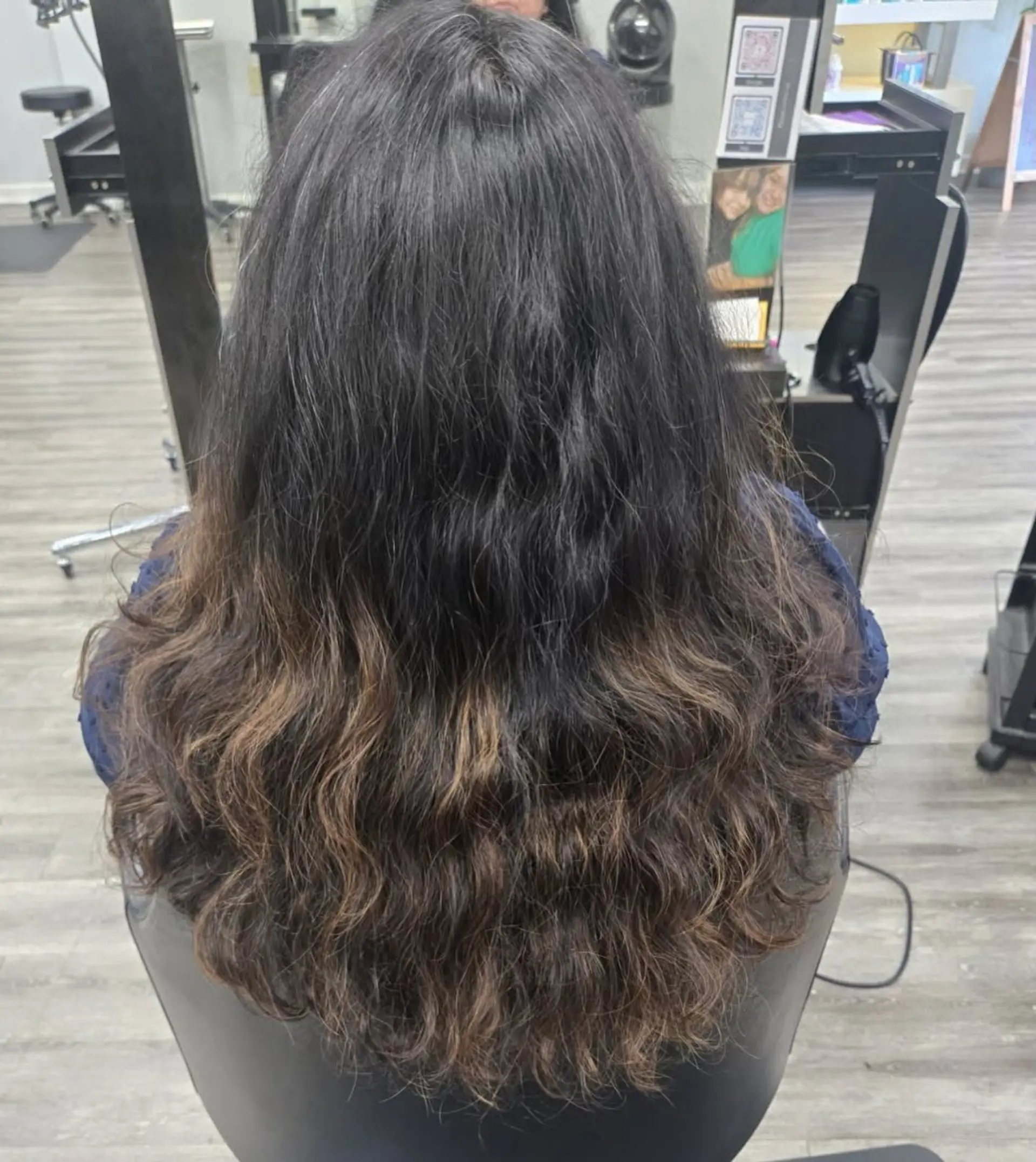 Long dark wavy hair with soft caramel-brown balayage highlights blended through the mid-lengths and ends. 1